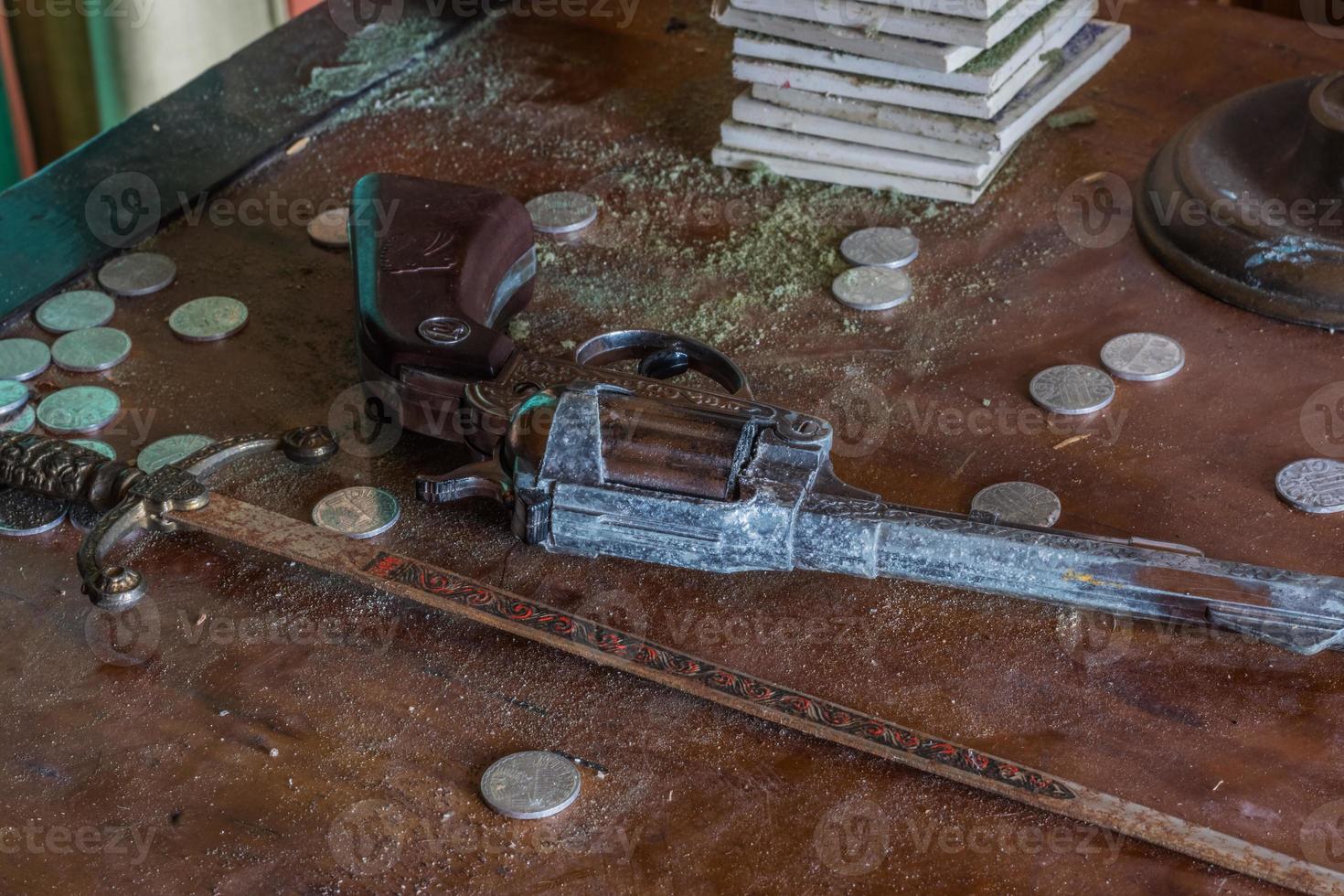 little sword pistol and coins in a room from a house photo