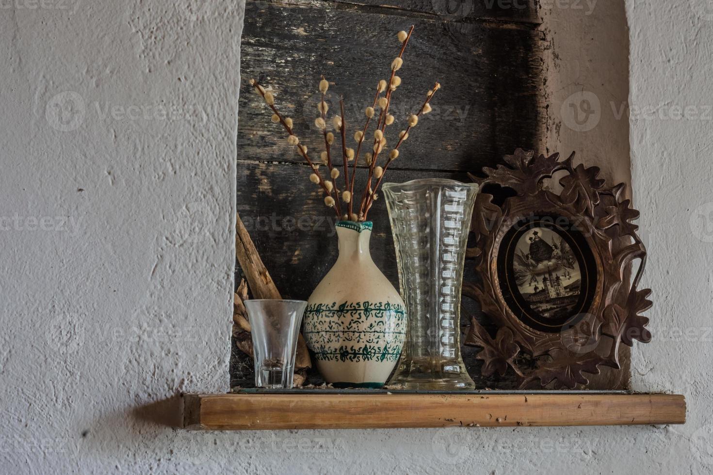 catkins in a vase and picture on a wald from a room photo