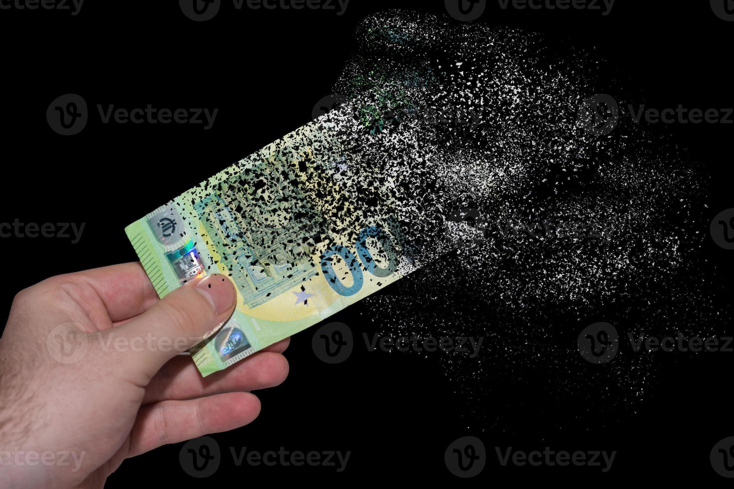 single euro bank note held in one hand decomposes and dissolves due to inflation with black photo