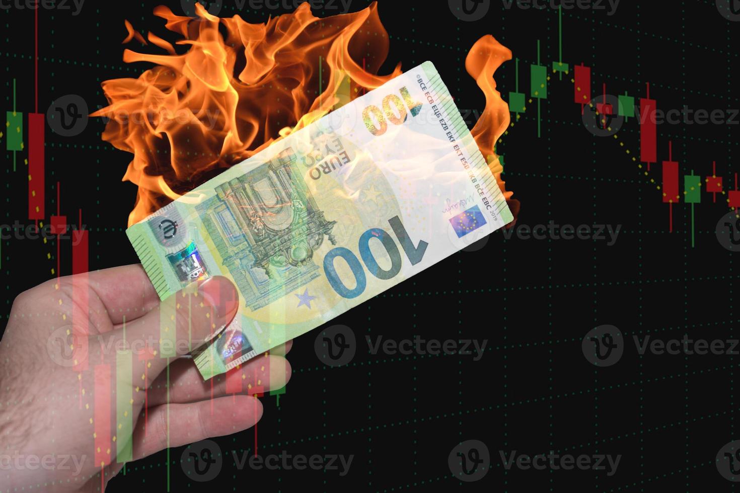 hand helding one burning euro bank note with a chart from the finance market black photo