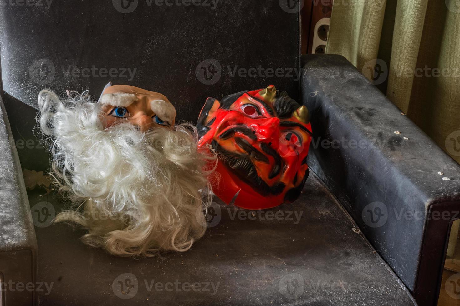 máscaras de san nicolás y diablo en un sillón en una casa foto