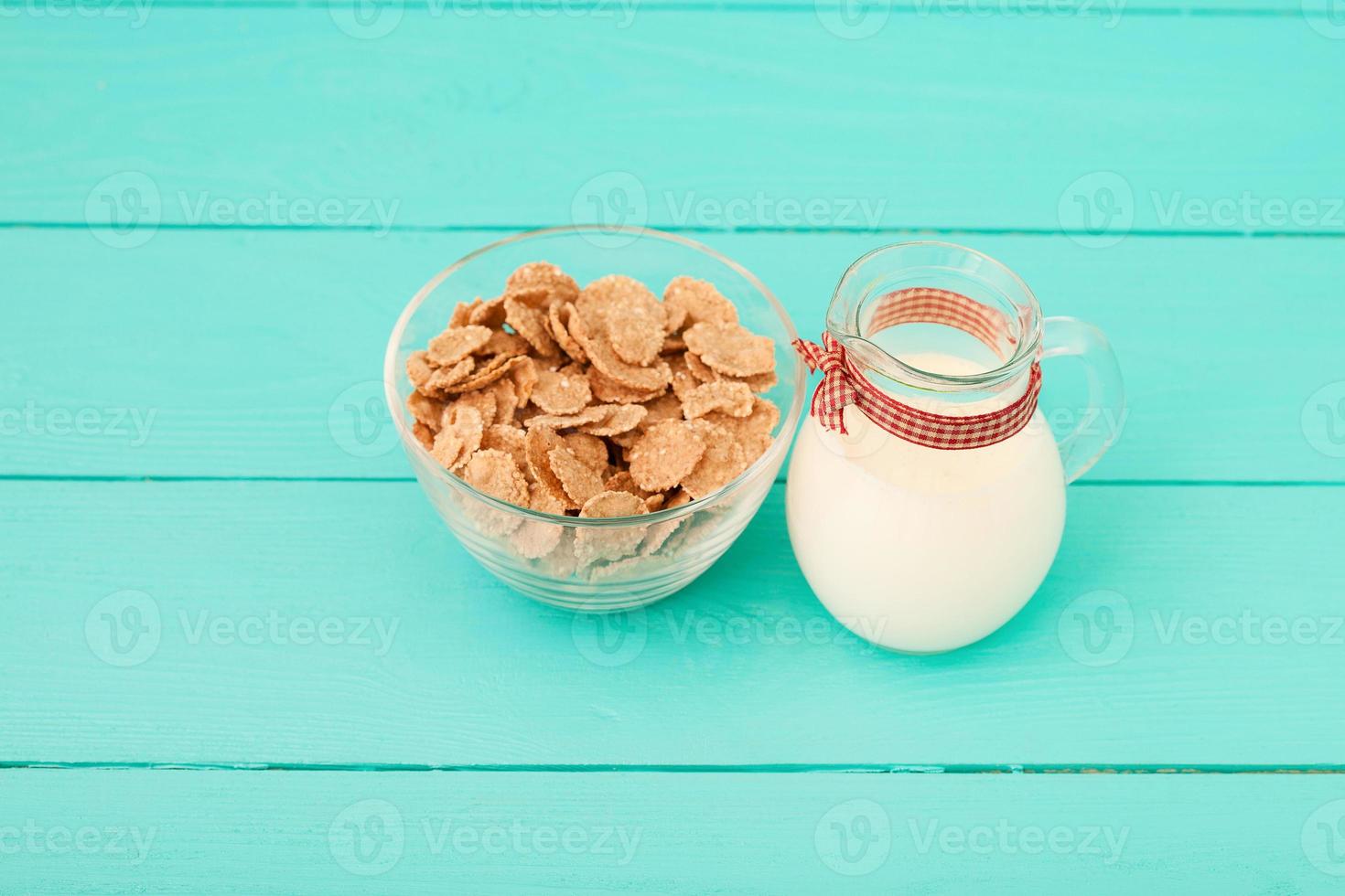 Milk, cookie, oat flakes. Breakfast and pink rose on blue wooden background and lace napkin. Top view and copy space. Mothers day. photo