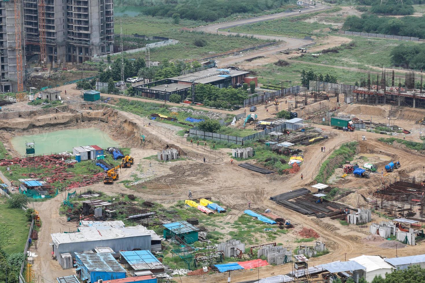 Aerial drone image of a construction site. Heavy equipment is grading the land, moving and flattening out red clay soil. photo