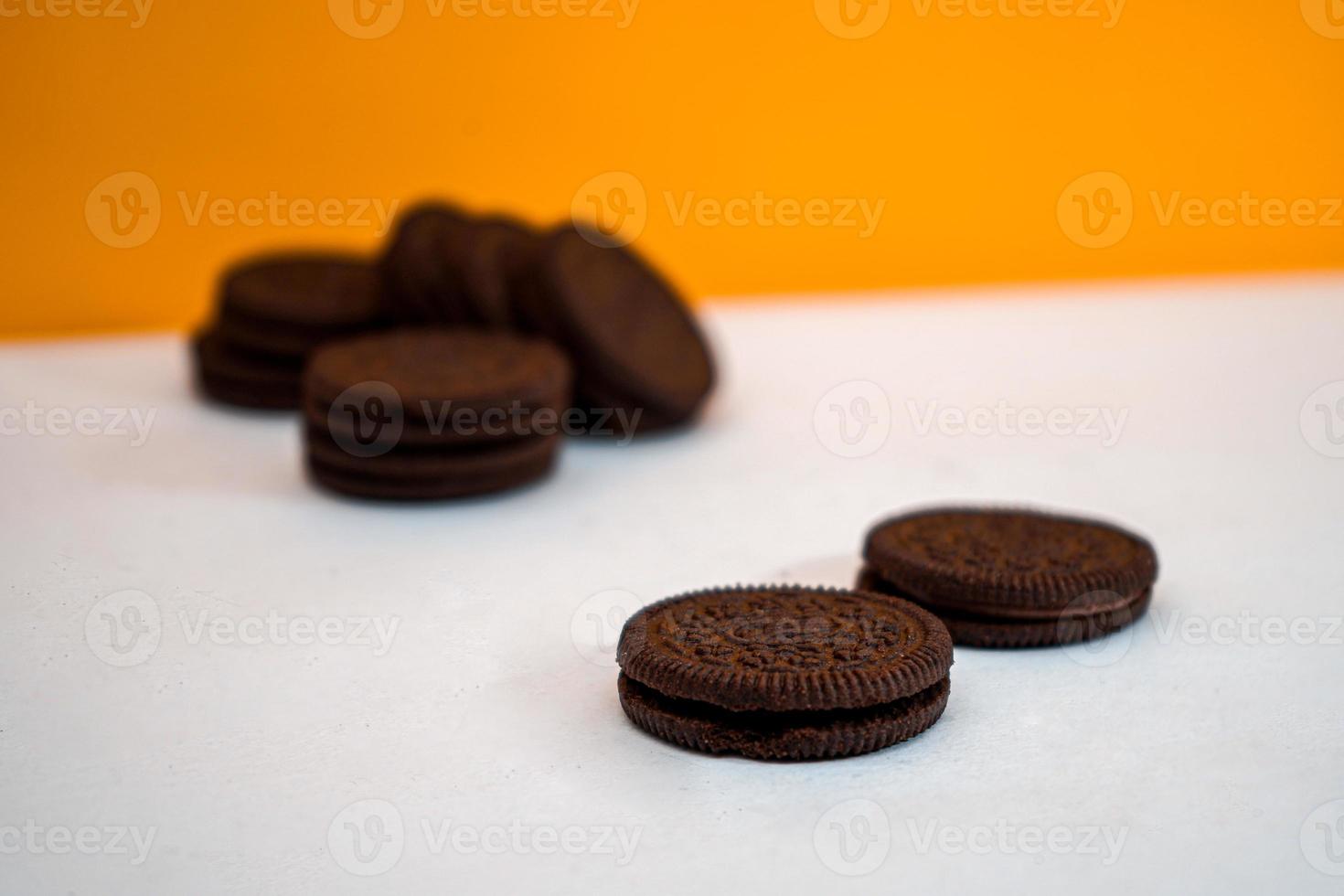 galletas de chocolate guardadas en un patrón sobre un papel blanco con un fondo amarillo foto