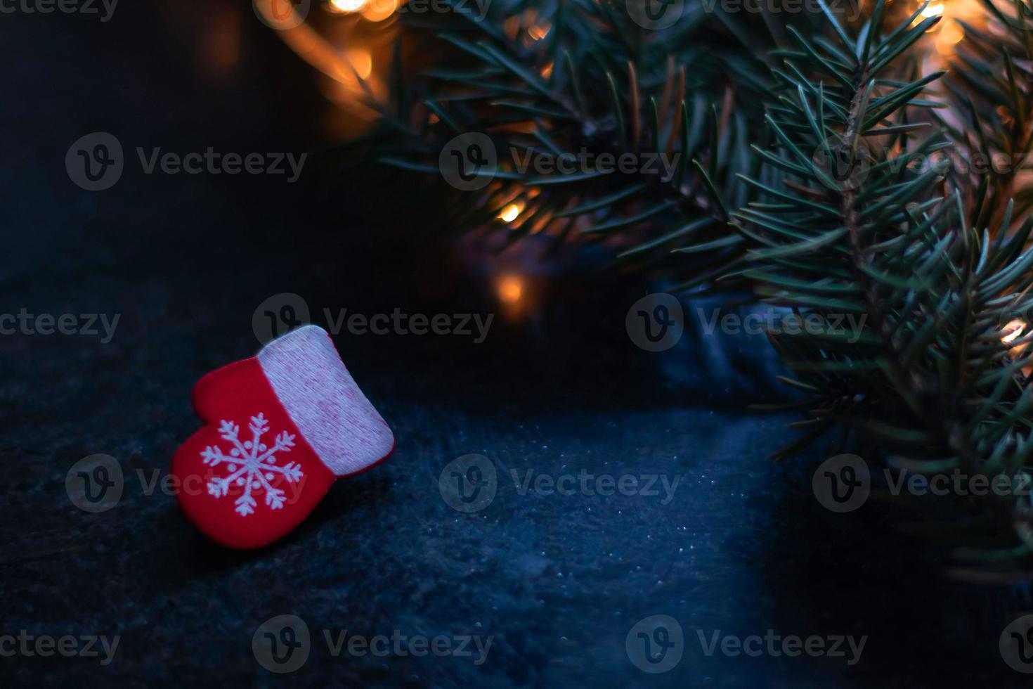 manopla de madera roja de juguete de árbol de Navidad con un copo de nieve sobre un fondo borroso. copie el espacio foto