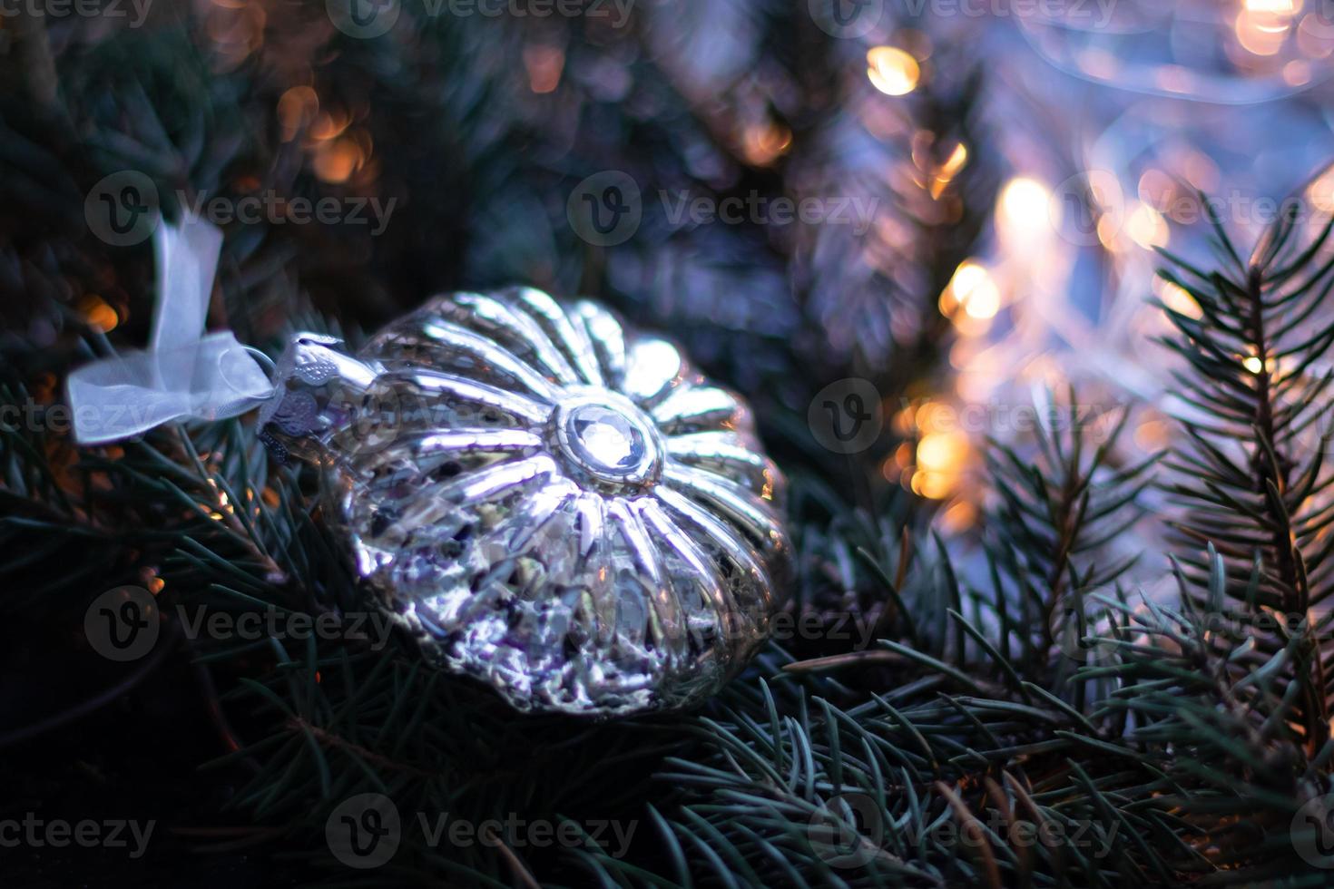 Christmas toy, silver ball on Christmas tree branch. Copy space photo