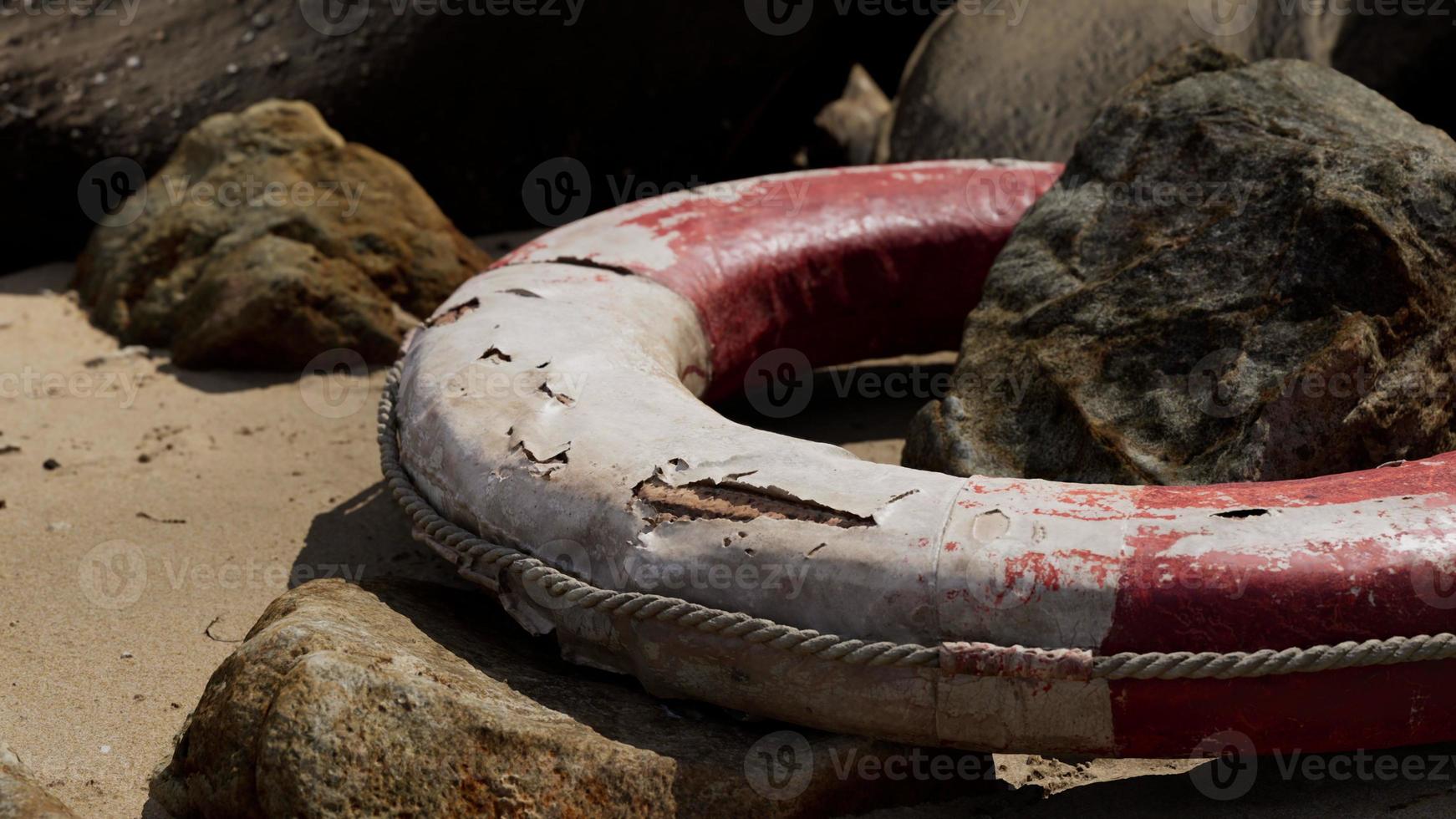 old life buoy on sandy beach photo