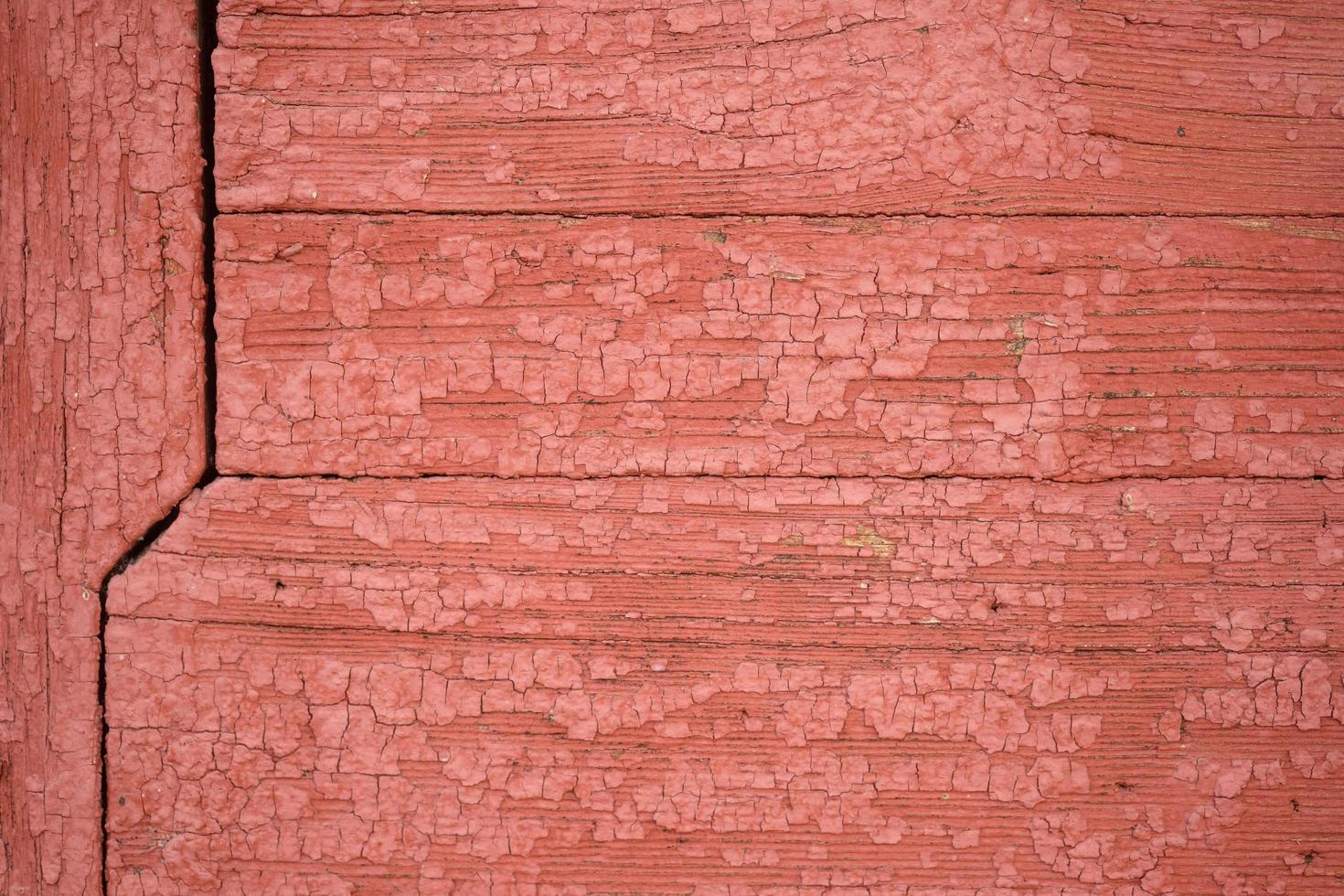 the wall is made of old boards with remnants of red paint photo