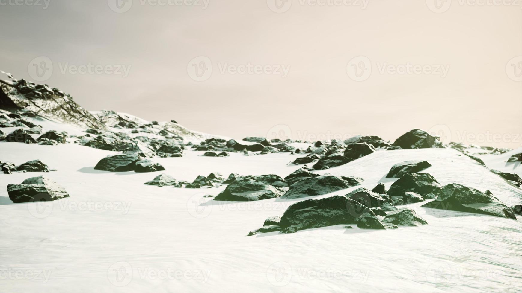 Snowy mountains and dark rocks photo