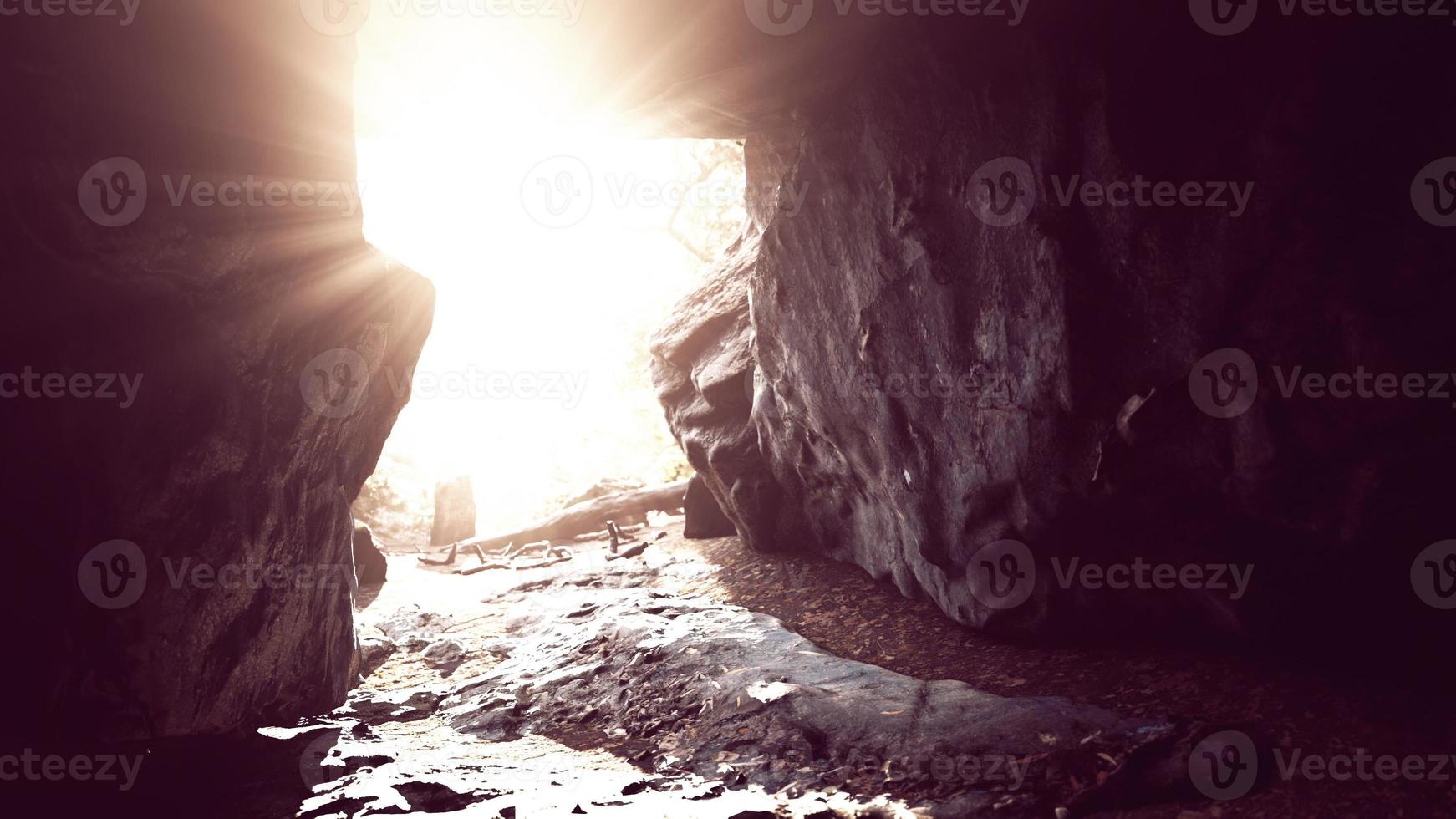 impresionante paisaje de brillantes rayos de sol cayendo dentro de una cueva iluminando foto