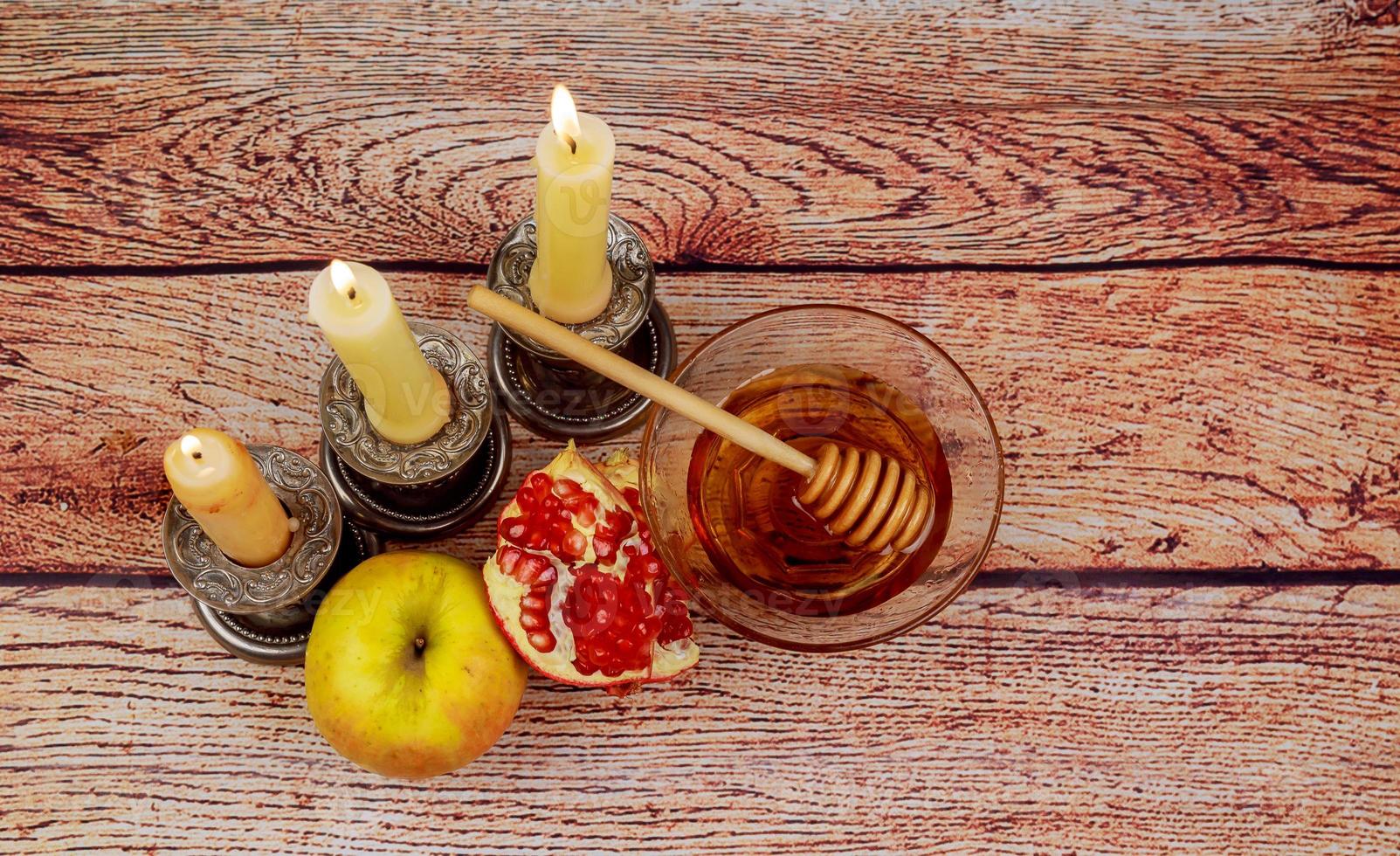 rosh hashaná jewesh vacaciones libro de torá, miel, manzana y granada sobre mesa de madera. símbolos tradicionales. foto