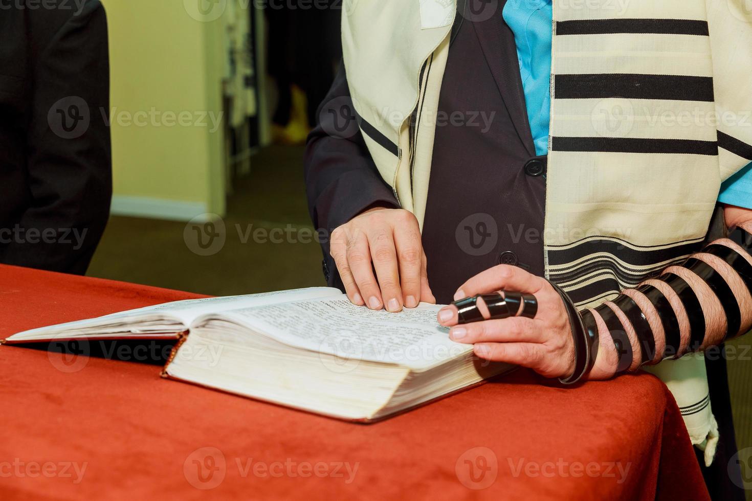 mano de niño leyendo la torá judía en bar mitzvah foto