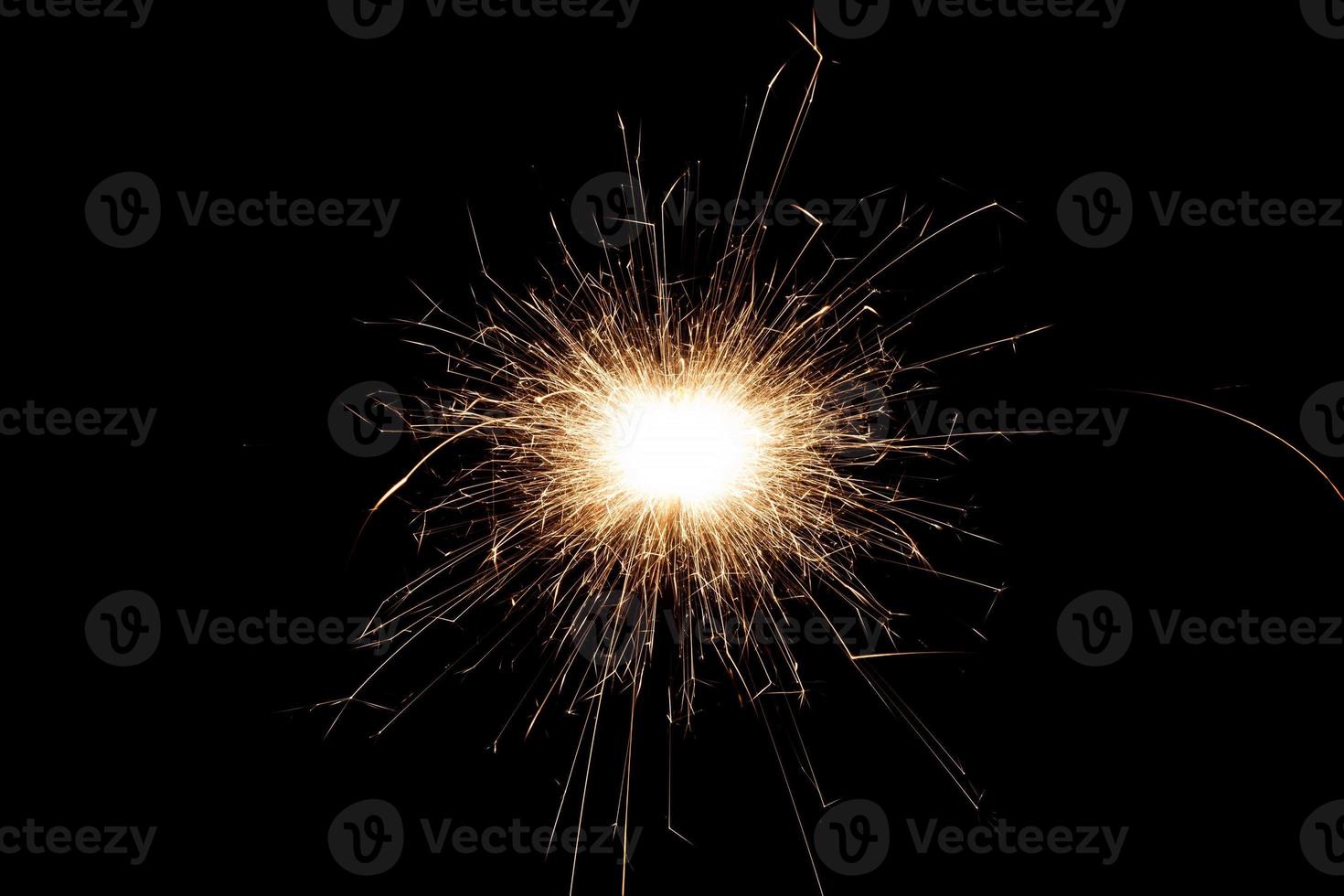 Burning sparkler isolated on black background. Fireworks theme. Light effect and texture. photo