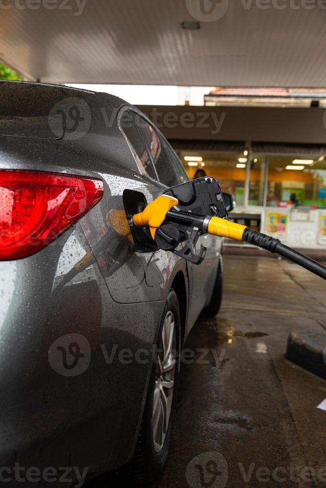 Pumping gasoline fuel in car at gas station. Car refueling fuel on petrol station. Service is filling gas or biodiesel into the tank. photo