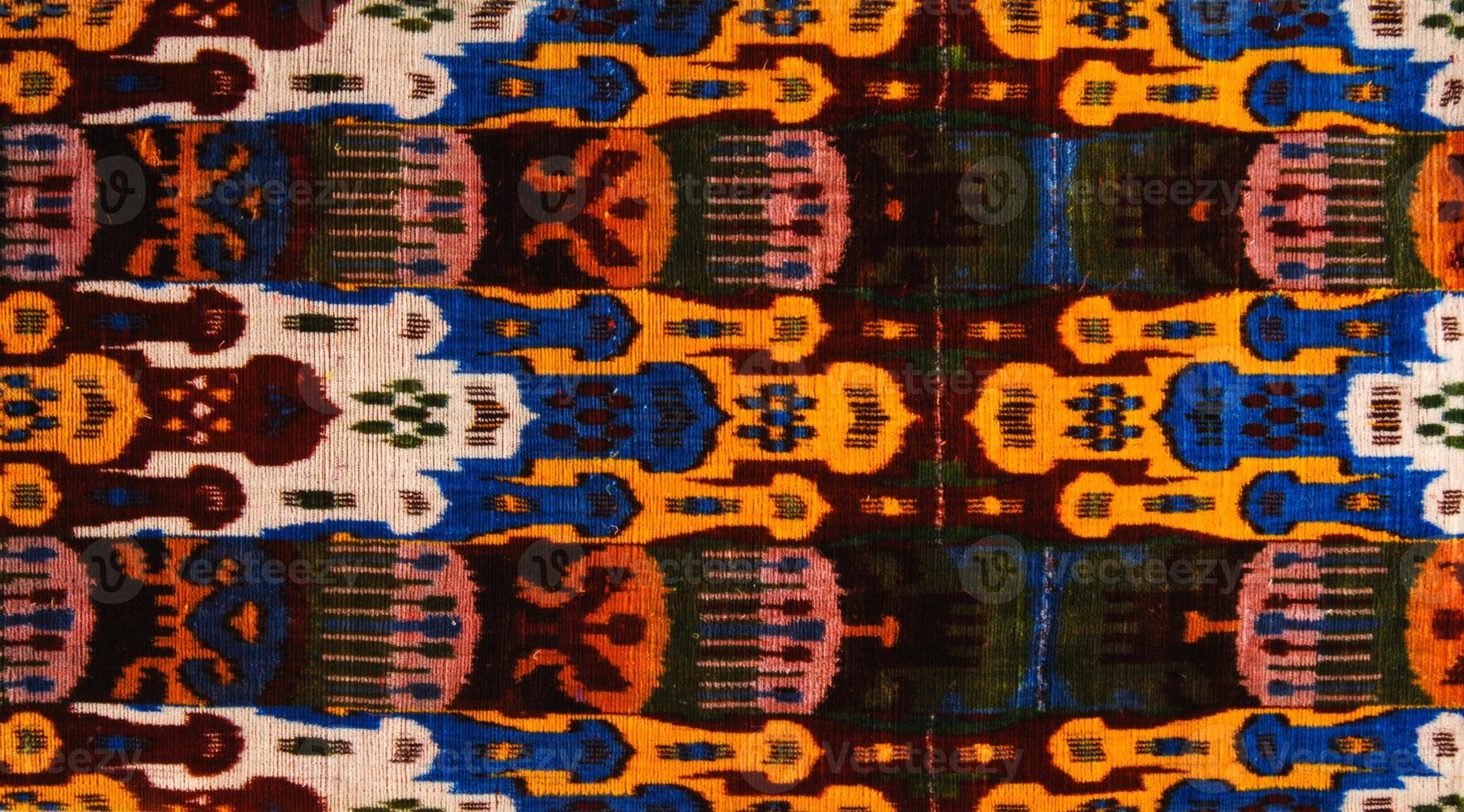 Background from the tissue with oriental ornaments and multi colored pattern, textile photo