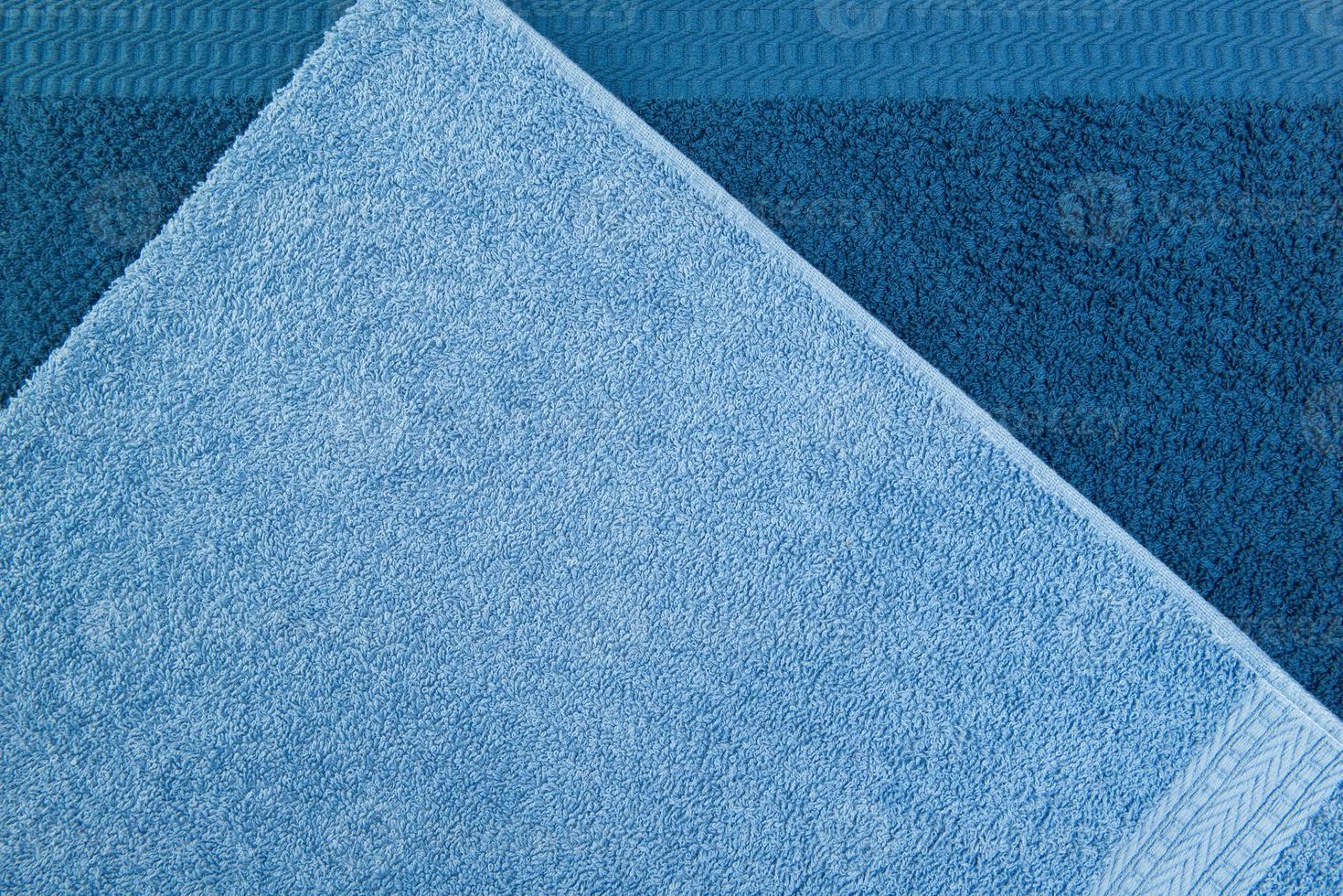 bath towel one on the other, blue. textured fabric background photo