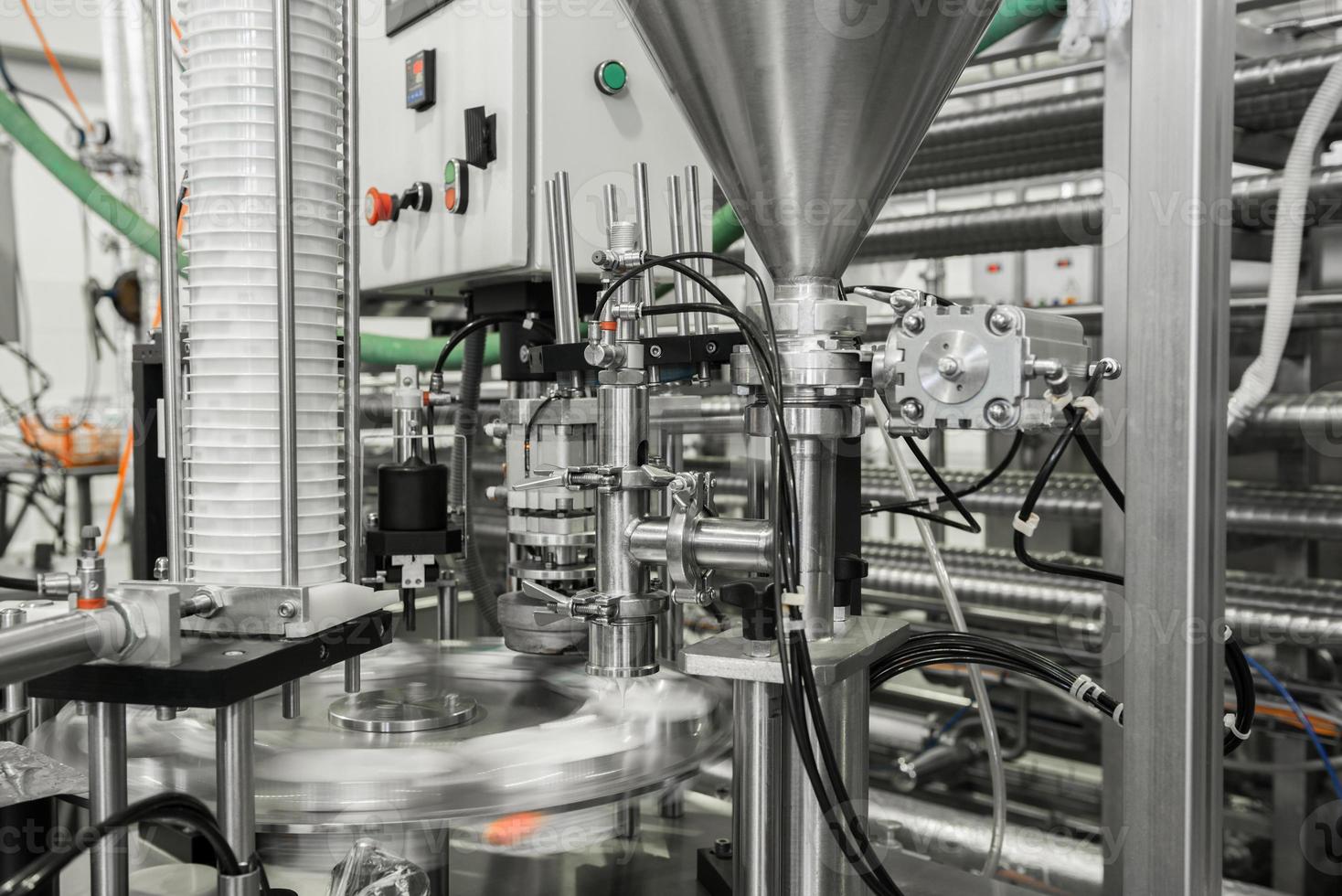 production and bottling of yogurt in plastic cups. equipment at the dairy plant photo