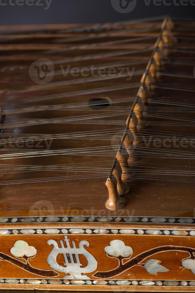 ancient Asian stringed musical instrument on black background with backlight. the similarity of the harp and psaltery. closeup photo