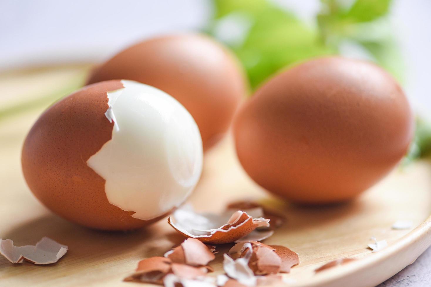 Peeled eggs menu food boiled eggs in a wooden plate decorated with leaves green vegetable and eggshell for cooking healthy eating photo