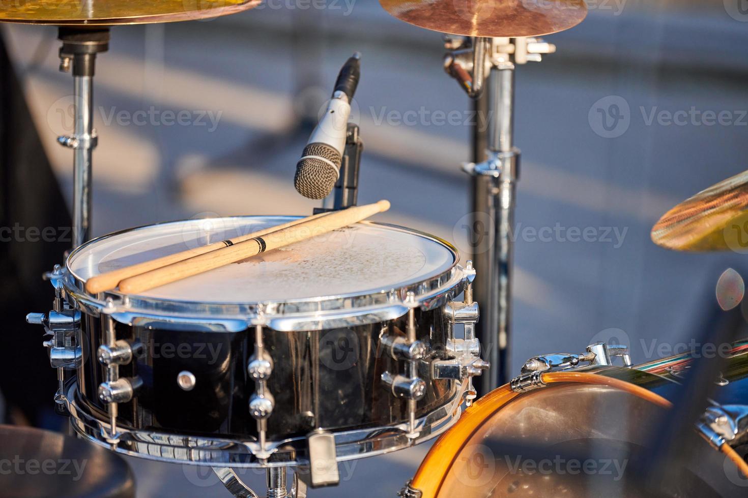 Drum kit at outdoor rock party close up, drumsticks on tom-tom drum at summer outdoor rock party photo