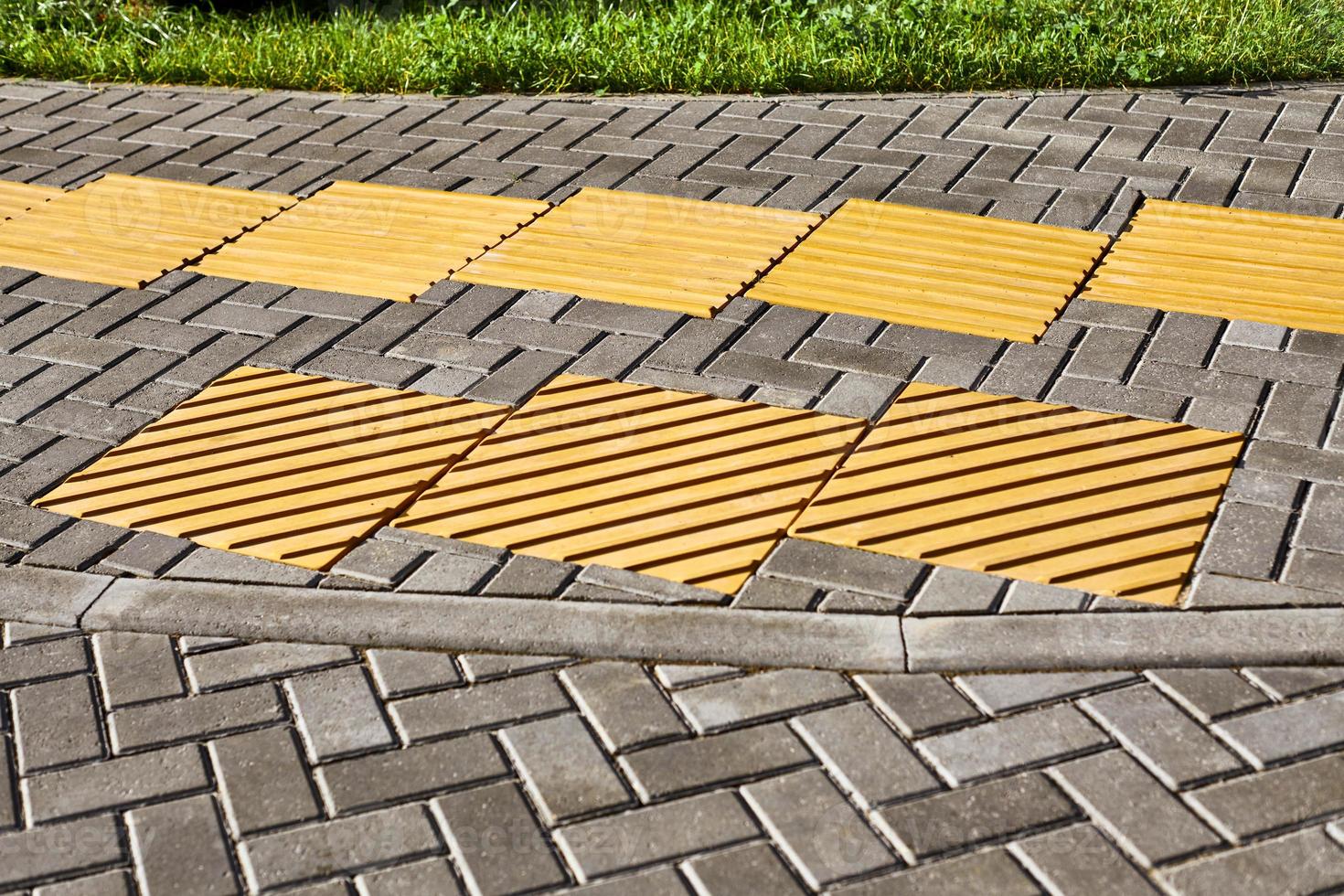 Yellow tactile paving on walkway, tactile ground surface indicators for blind and visually impaired photo