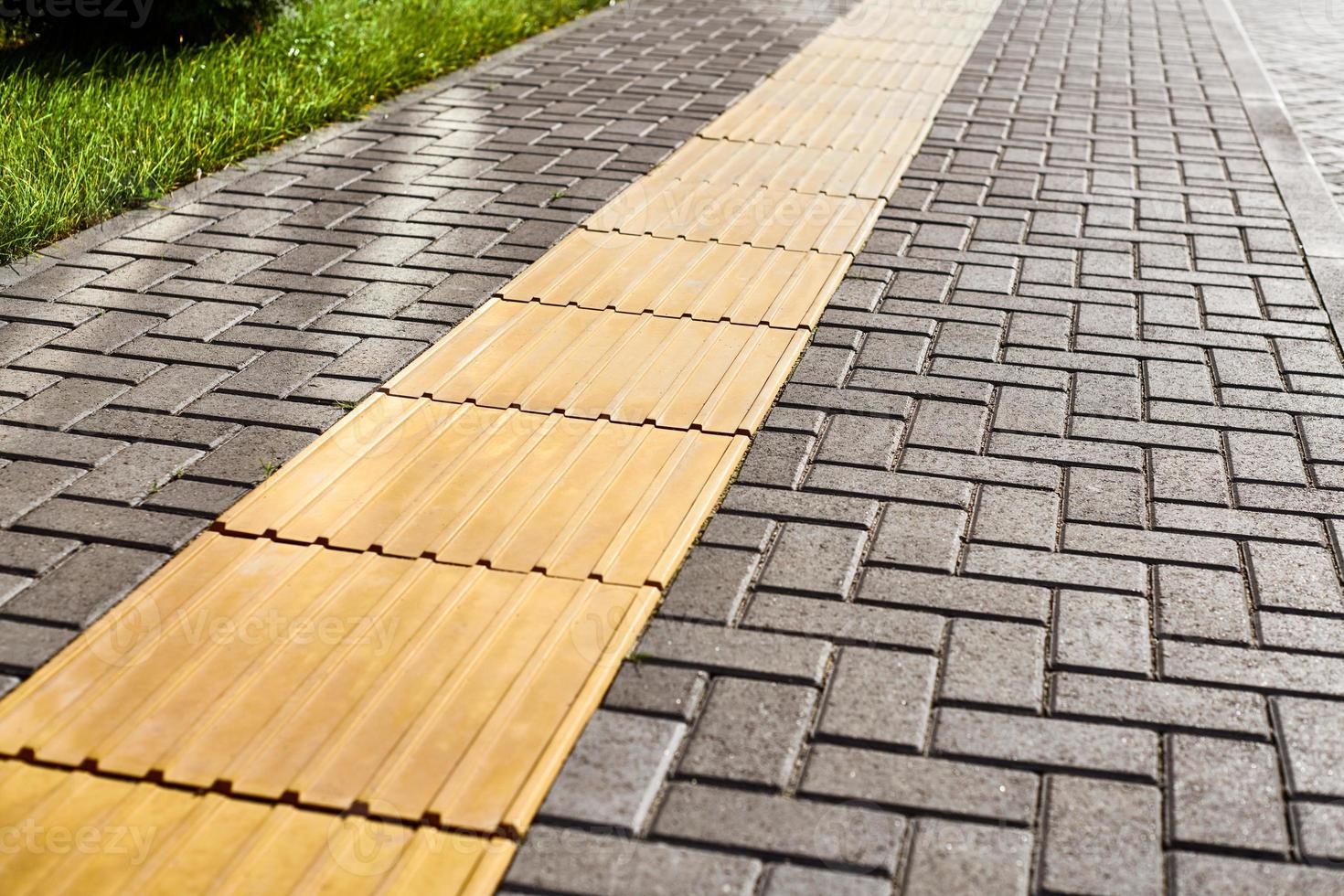 pavimentación táctil amarilla en la pasarela, indicadores táctiles de la superficie del suelo para ciegos y deficientes visuales foto