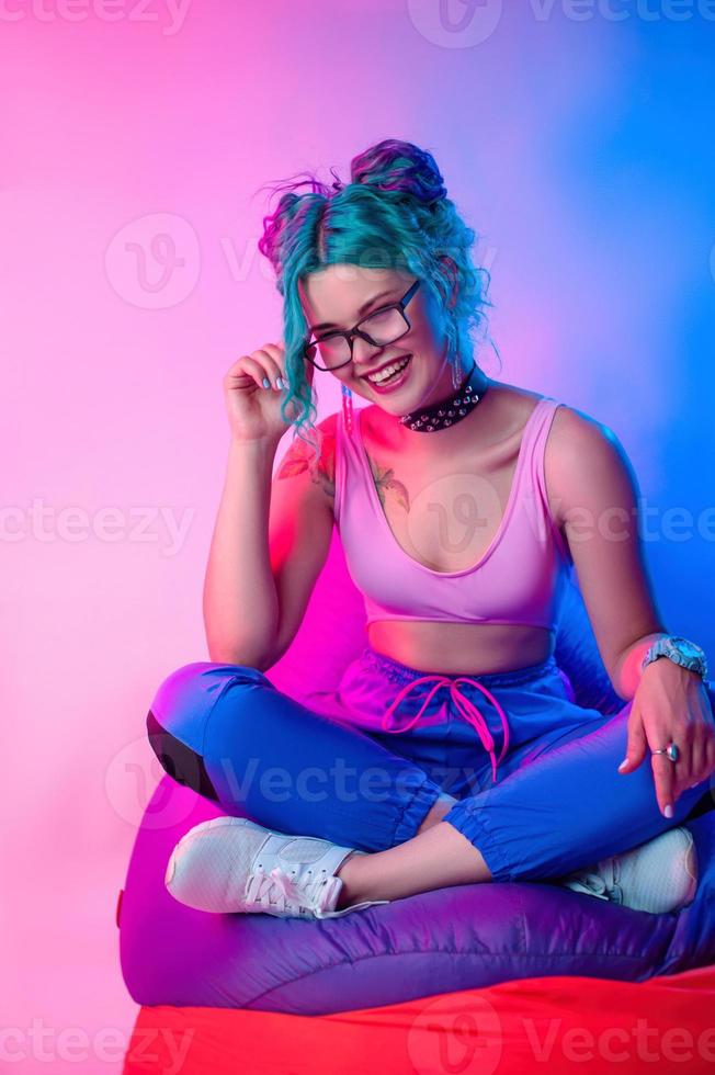 a woman in bright clothes with blue hair is sitting on a chair bag photo