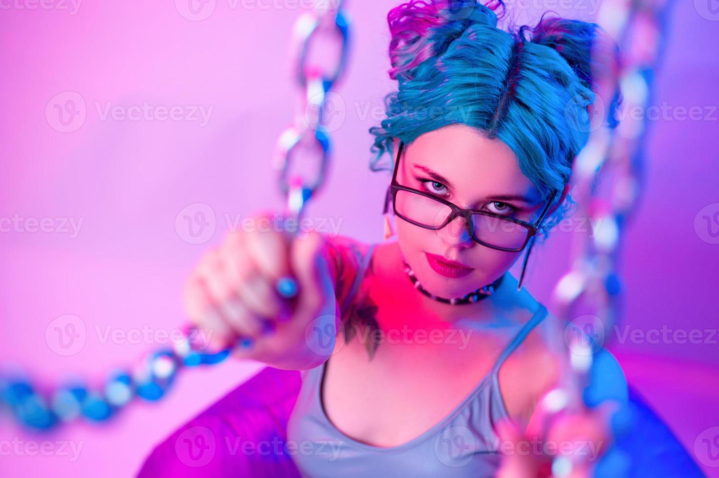 mujer sexy en traje de baño brillante con cabello azul en manos de la cadena foto