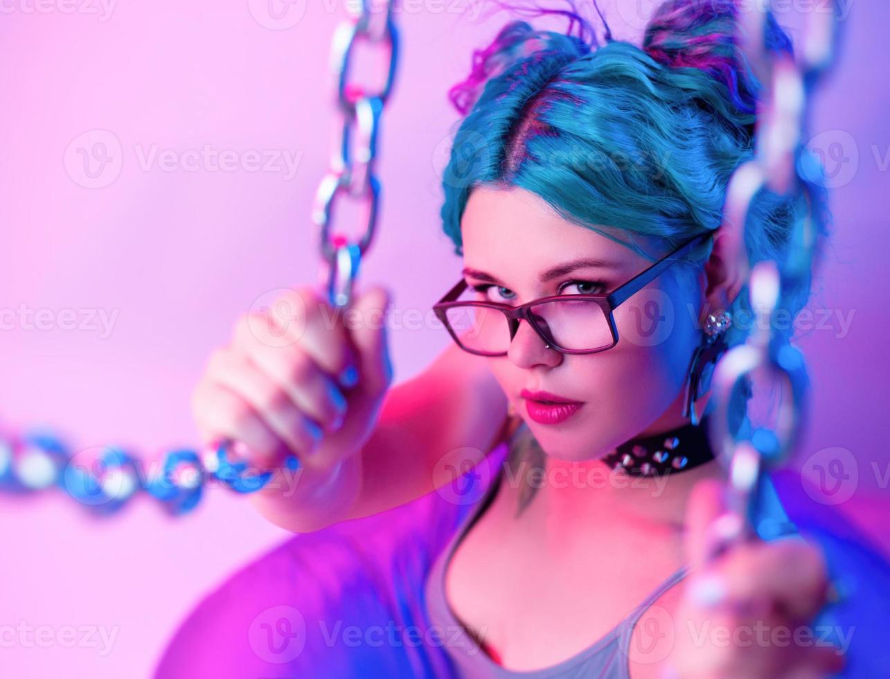 sexy woman in bright bathing suit with blue hair in the hands of the chain photo