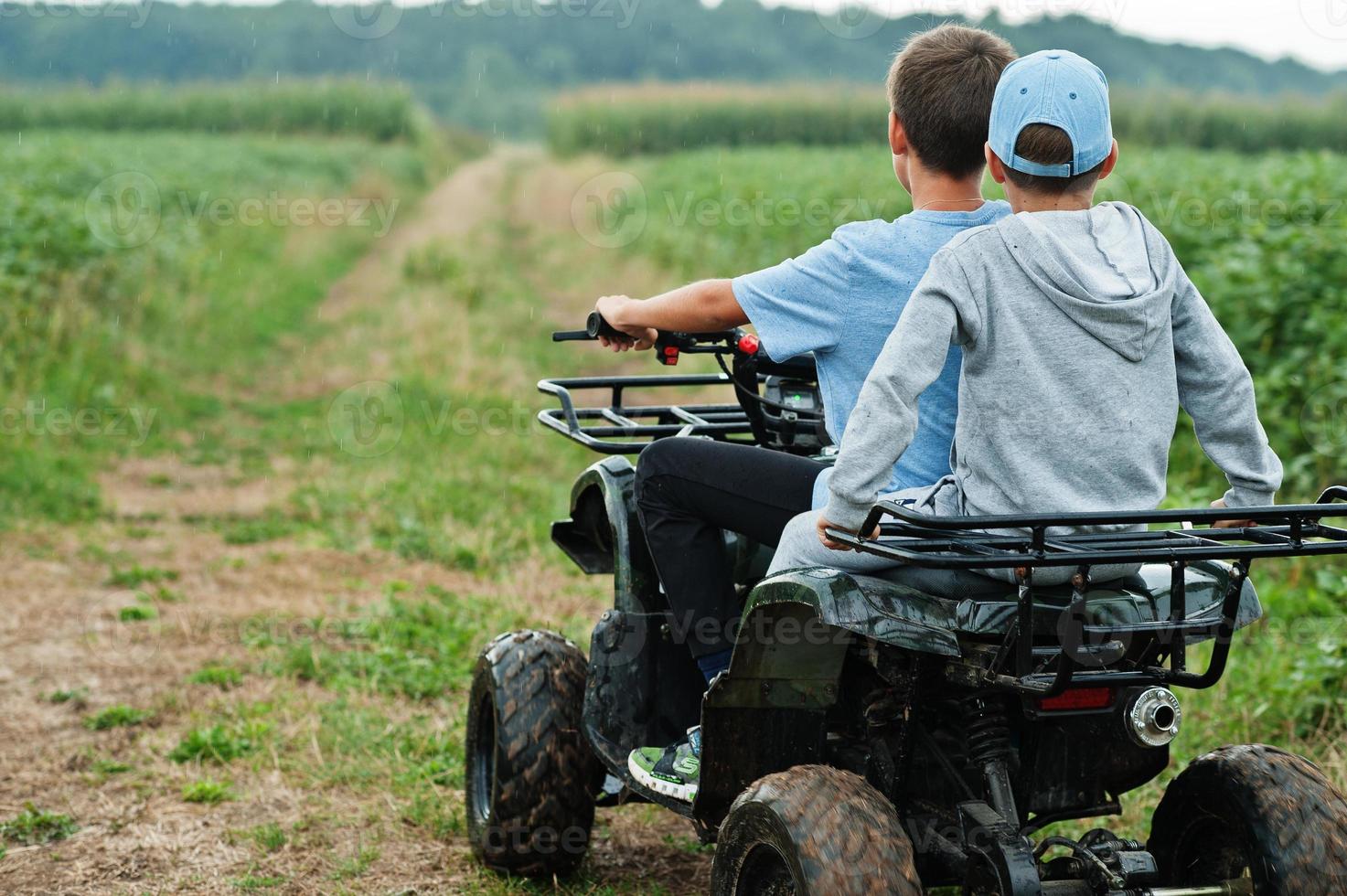 dos hermanos conduciendo quads de cuatro ruedas. momentos de niños felices. foto