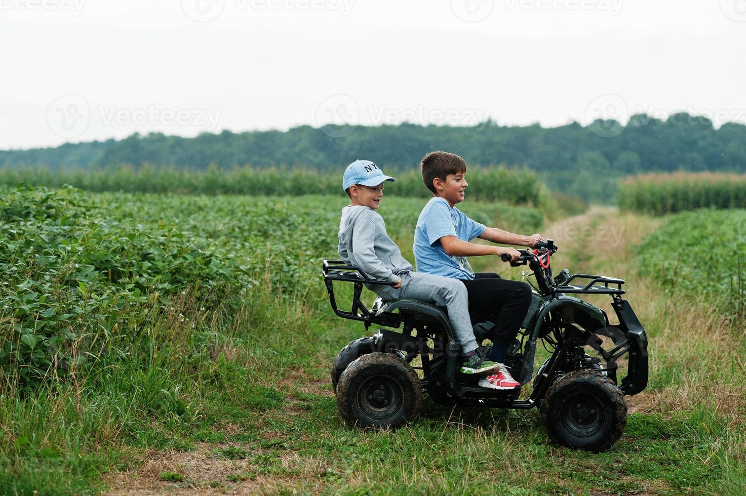 dos hermanos conduciendo quads de cuatro ruedas. momentos de niños felices. foto