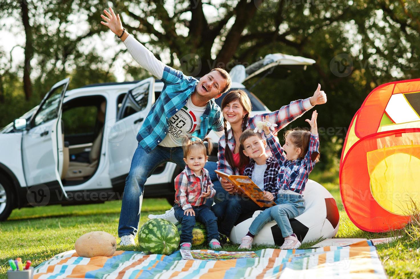 Family spending time together. Three kids. Outdoor picnic blanket. photo