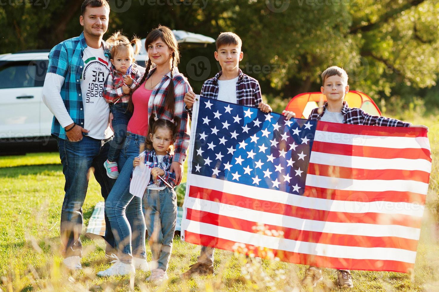 gran familia americana pasando tiempo juntos. con bandera de estados unidos. vacaciones de américa. cuatro niños foto