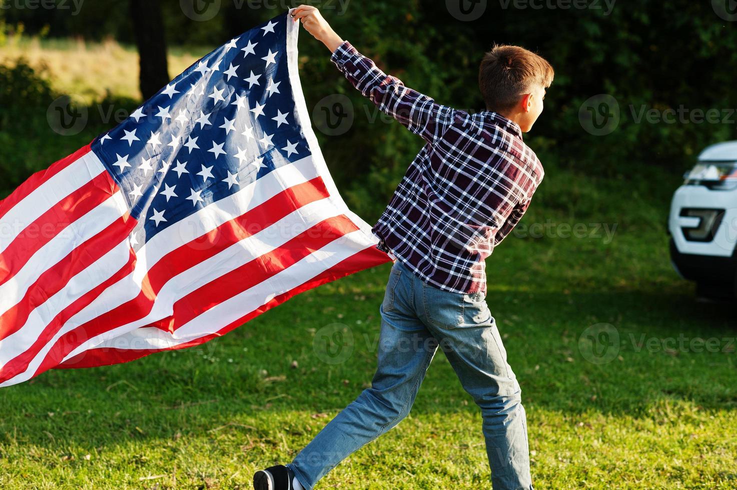 Boy with USA flag outdoor. America celebrating. photo