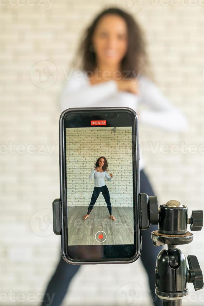 Latin woman created her dancing video by smartphone camera. To share video to social media application. photo