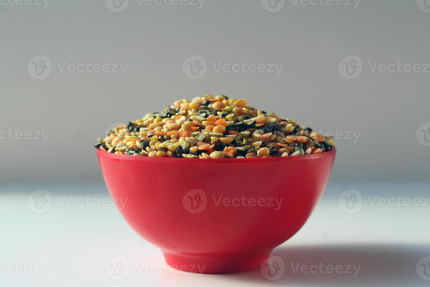 A bowl of mixed lentils that are widely used in India. Lentils are Red lentil, Mung bean, Black gram, Pigeon pea, and split Chickpea. photo