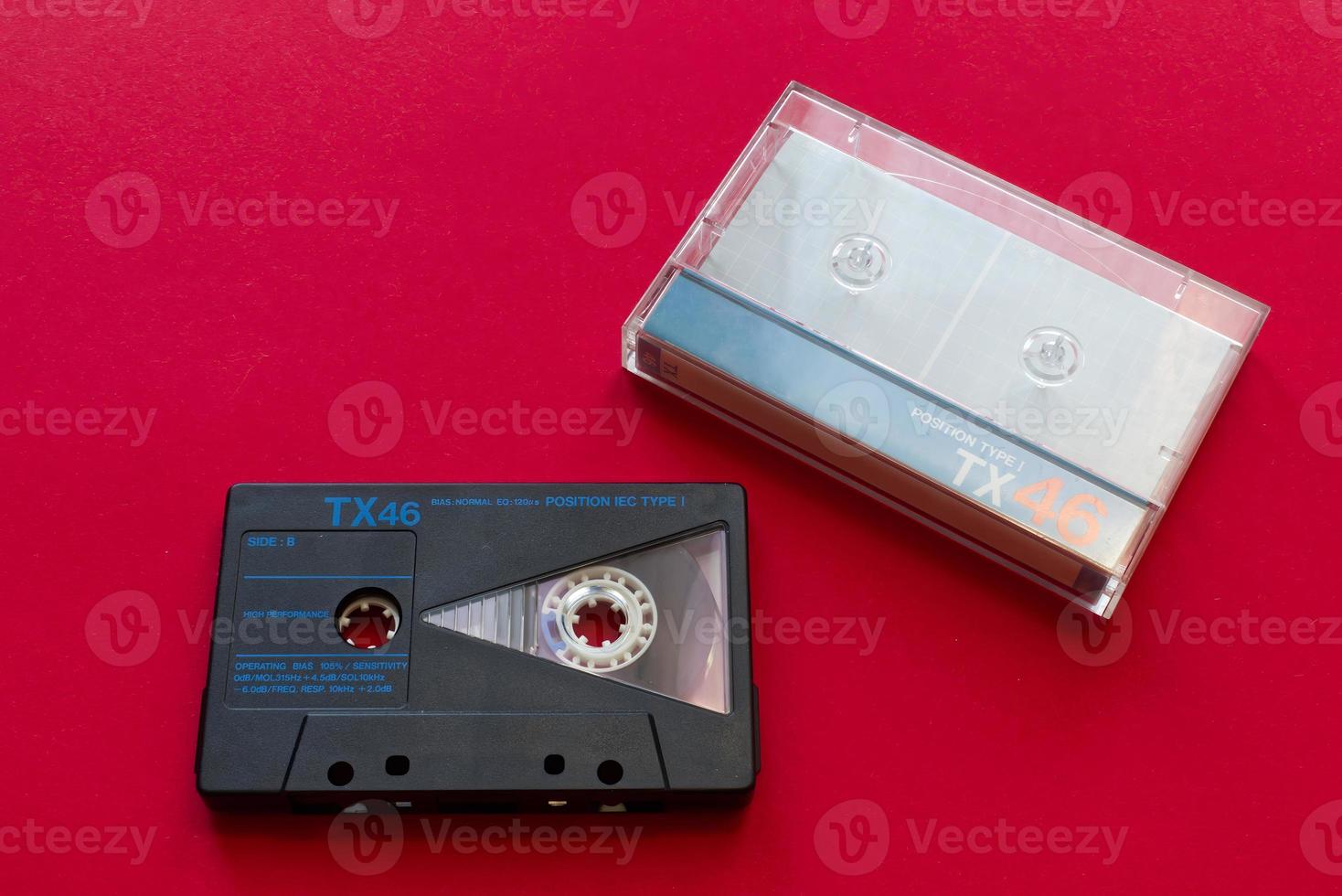 cinta de casete de audio vintage y caja de cinta de casete sobre fondo rojo. Tecnología de los 90. foto