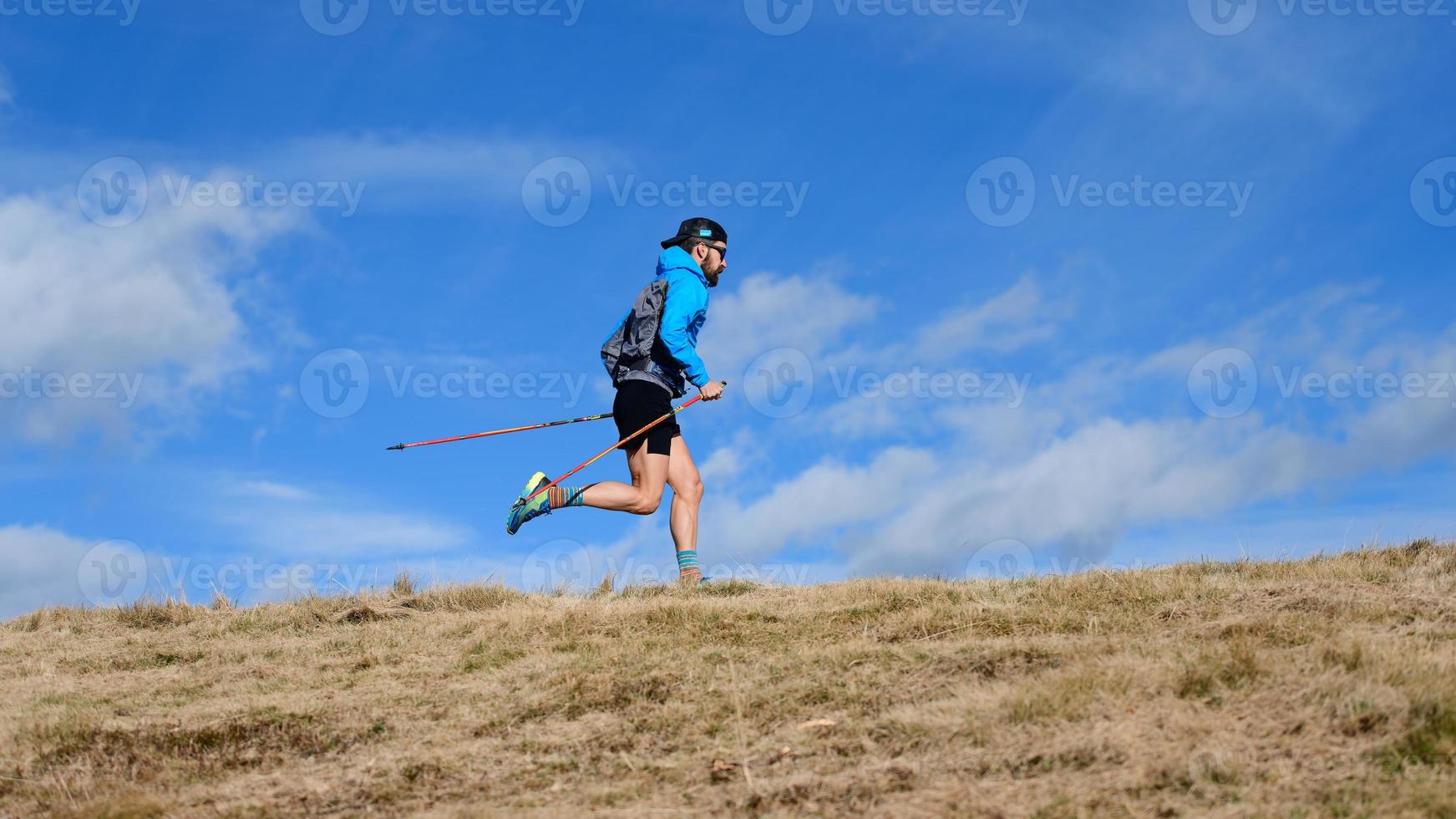 A sporty man with climbing poles during endurance trail photo