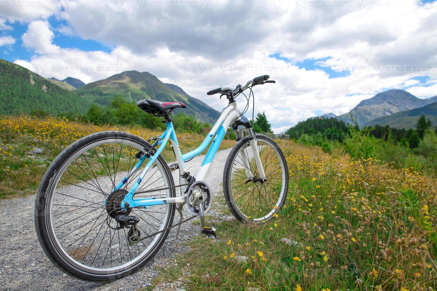 una bicicleta de turismo se detiene en un camino de tierra en las montañas foto