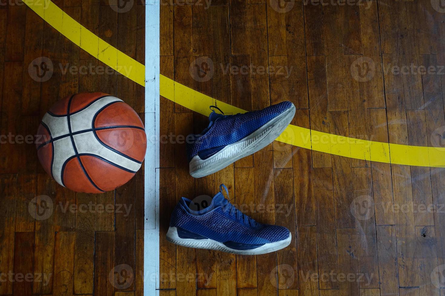 Top view of shoes and basket ball on wooden basketball court photo