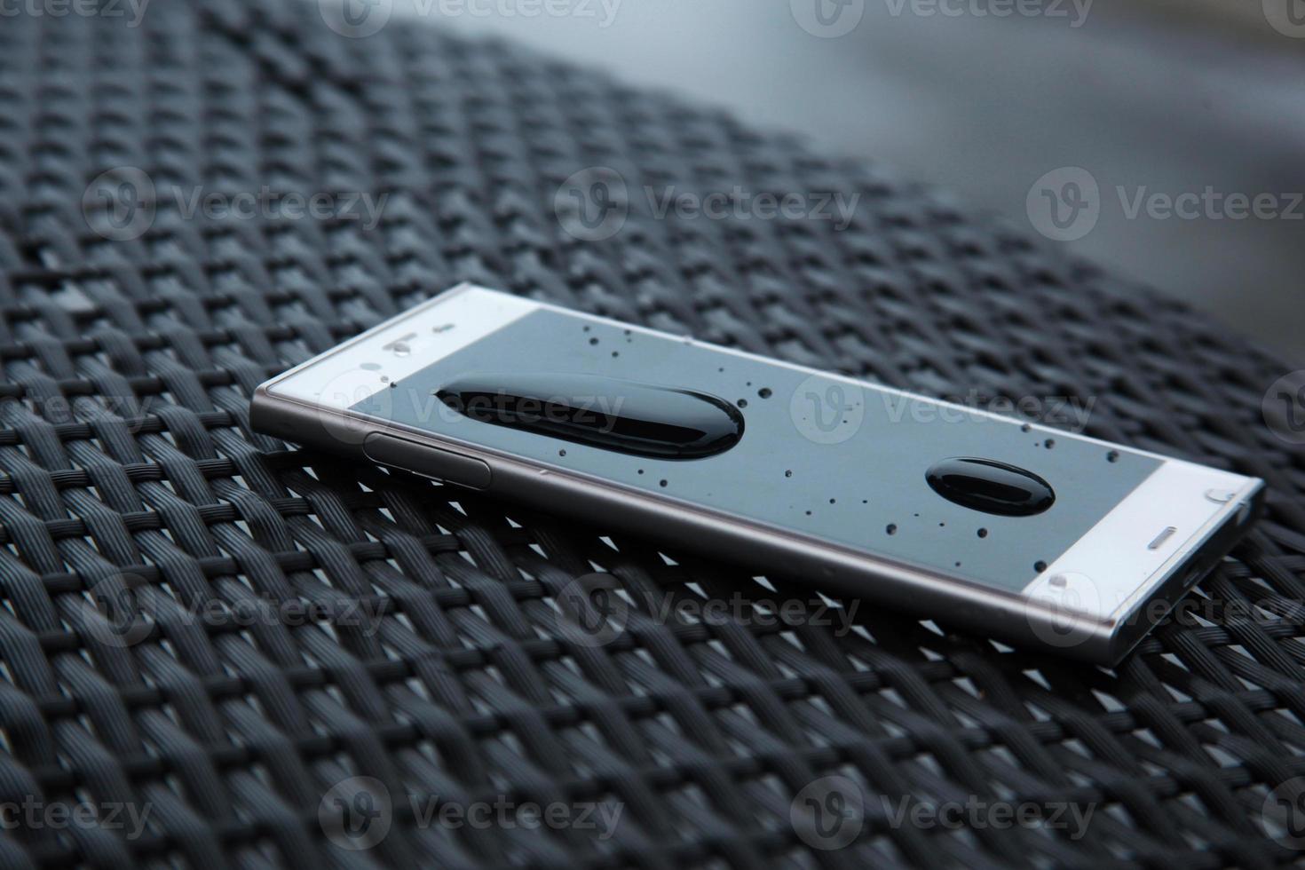 Modern water resistant smartphone with blurry pool background photo