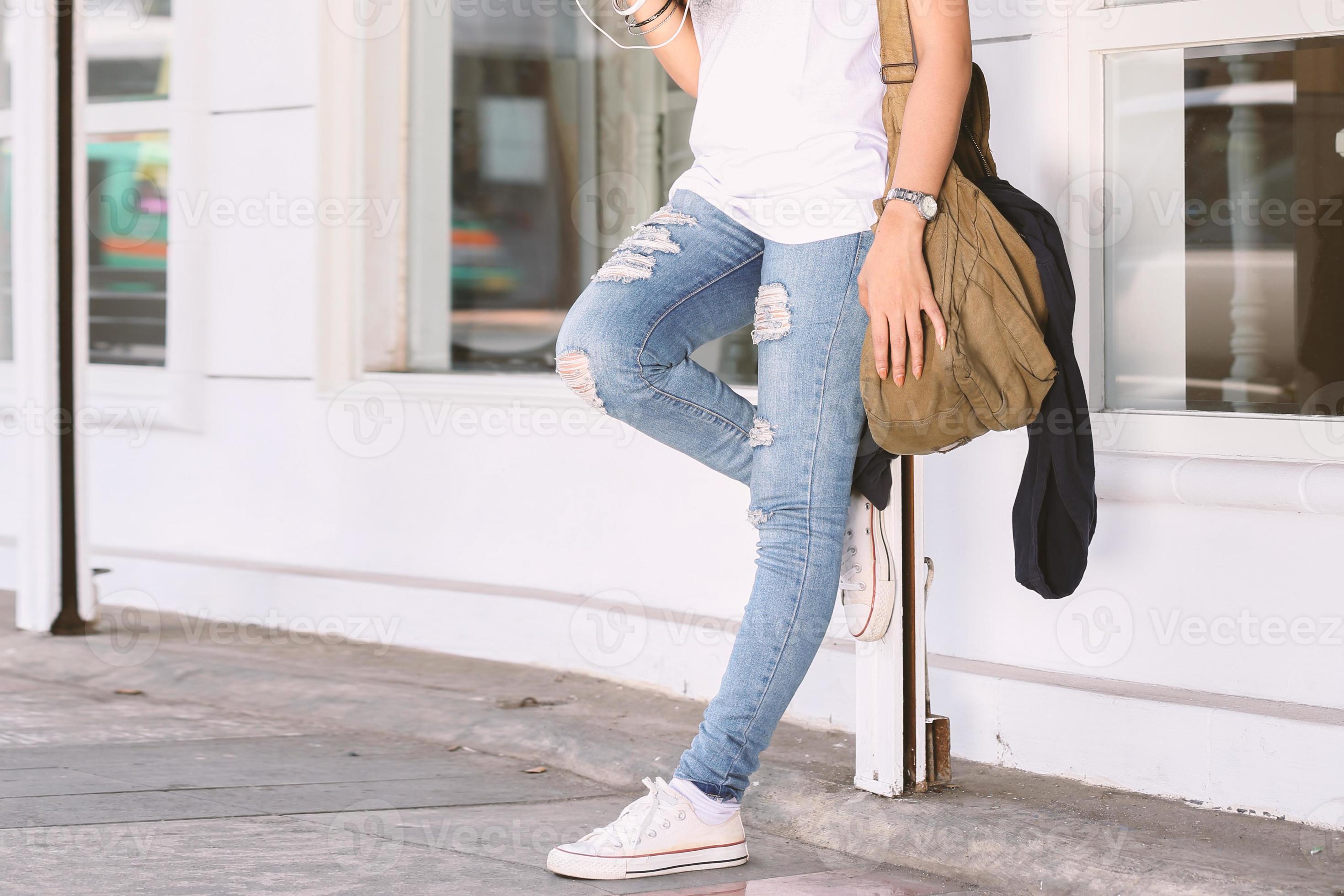 Girl wearing ripped jeans, sling bag, white tees, sneakers, hipster style,  casual, clothes for youth, no face, lower part of body, sporty style.  5686587 Stock Photo at Vecteezy