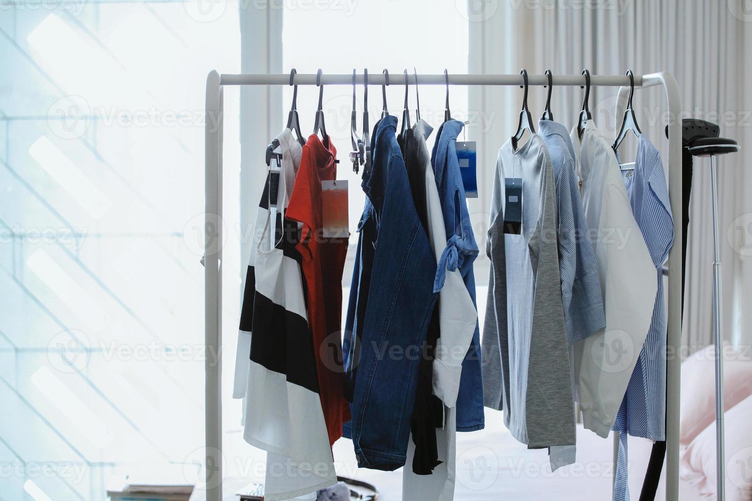 Stylish hanger clothes, female clothes on white room. Women's shirt and blouses on a hanger. Fashion blog for entrepreneurs, bloggers, magazines, websites, social media. photo