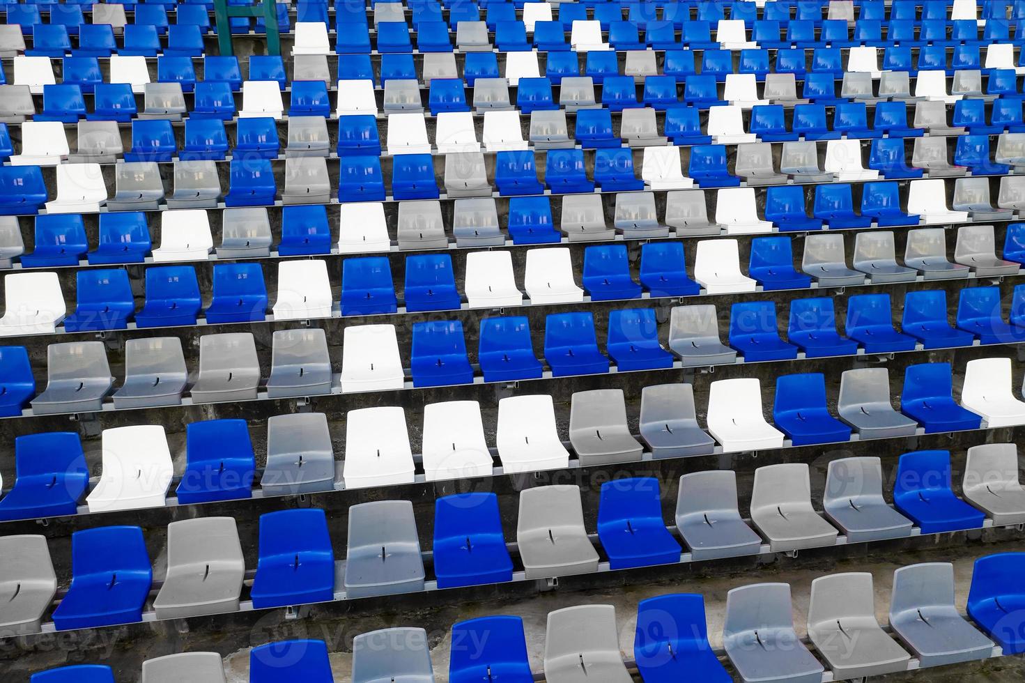 estadios anfiteatro asientos de plástico vacíos en el estadio. muchos asientos vacíos para los espectadores en las gradas para los fanáticos del fútbol y otros deportes al aire libre. un lugar público que el gobierno crea para el público. foto