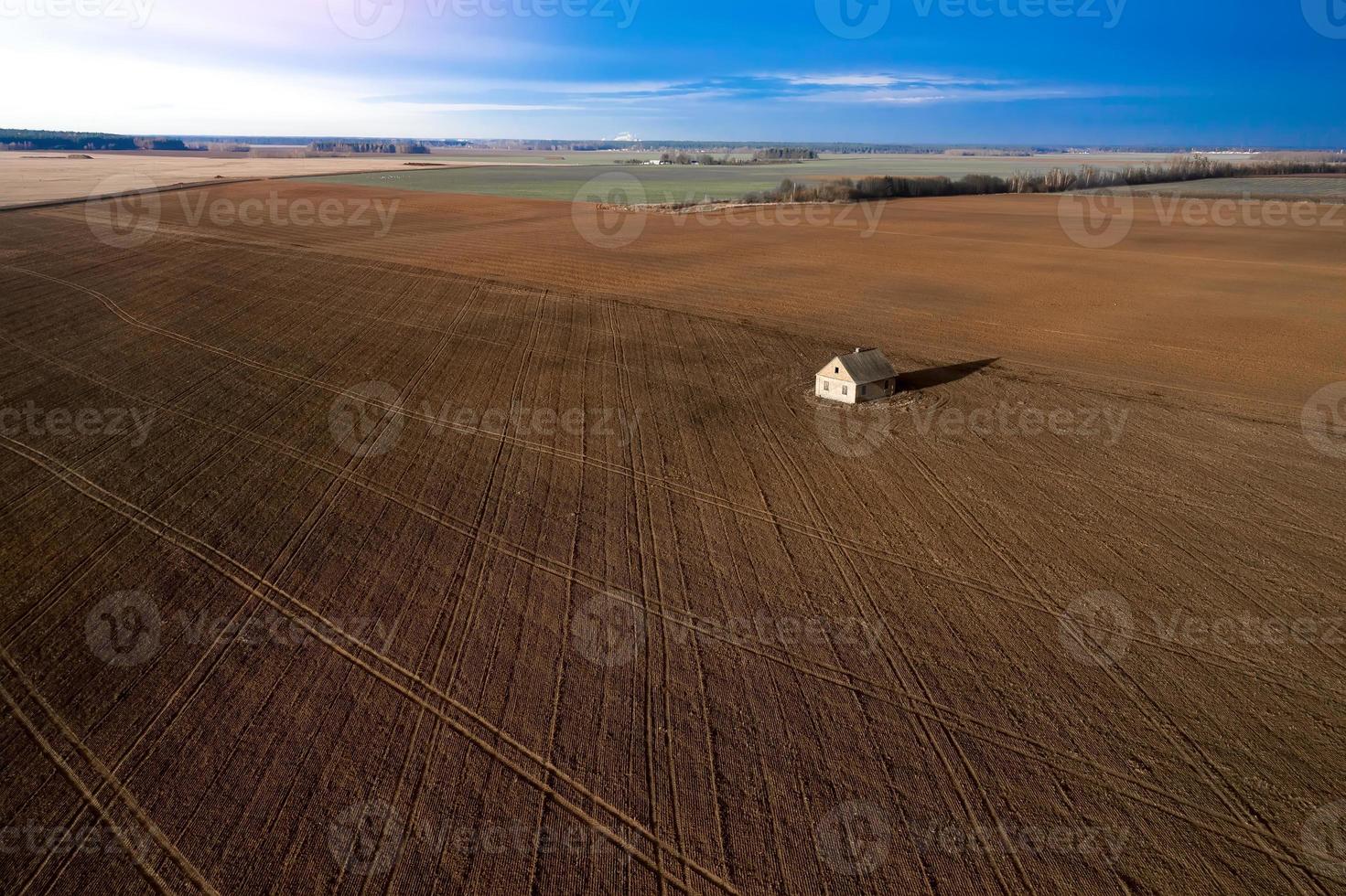 casa abandonada en medio de un campo contra una vista superior del cielo tormentoso. foto