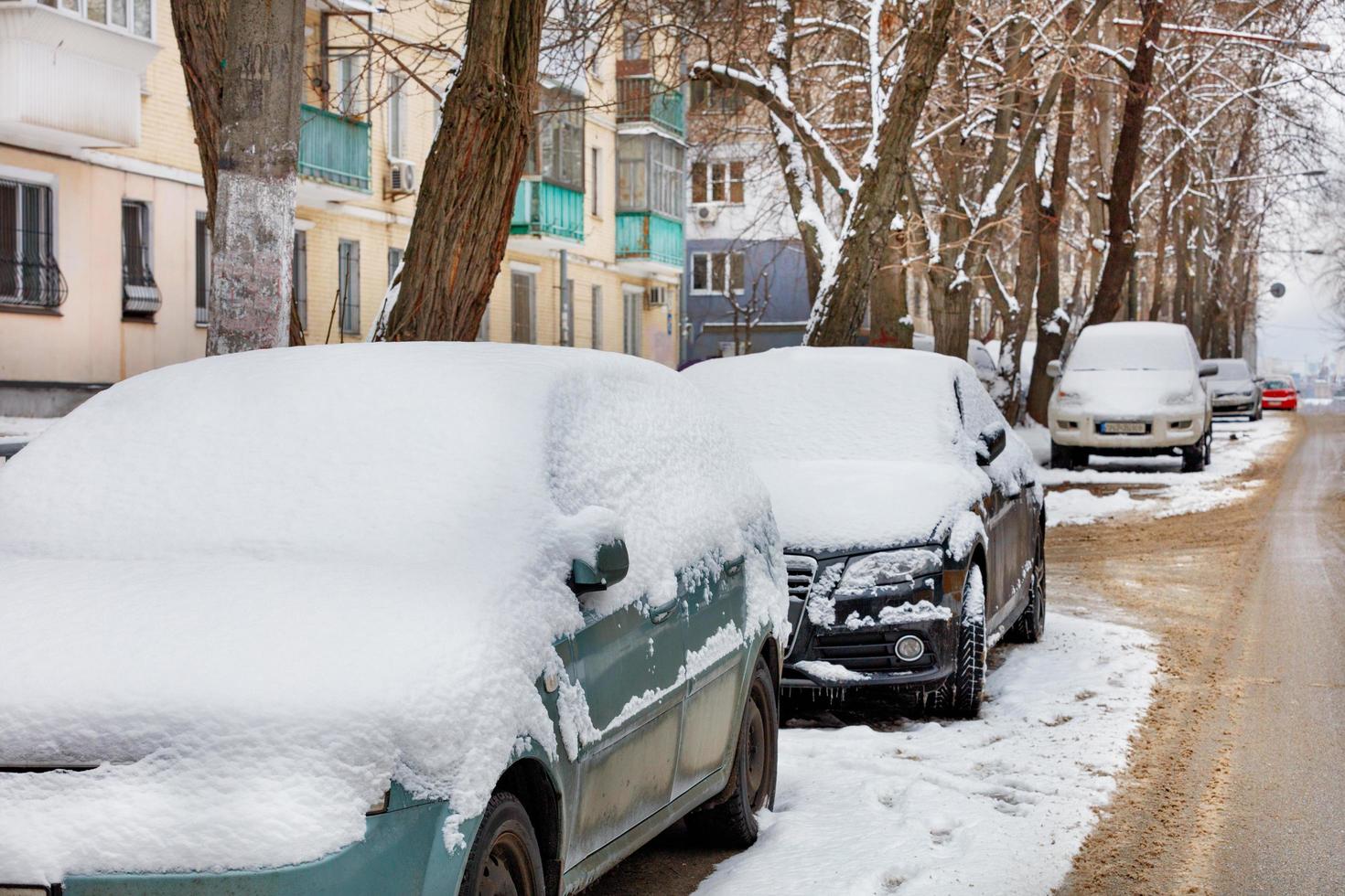 23.01.2022. kiev Ucrania. los autos cubiertos de nieve están estacionados a lo largo de la calle de la ciudad. foto