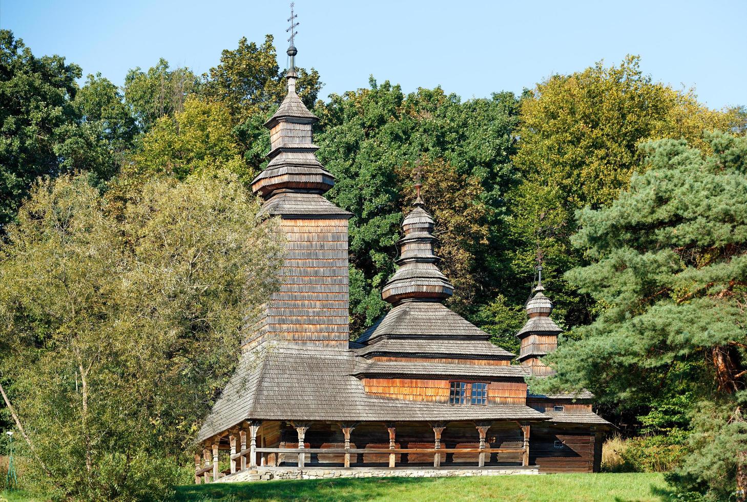 10.09.2021. Kyiv. Ukraine. An old Carpathian wooden Ukrainian church on a hill against the backdrop of a dense forest. photo