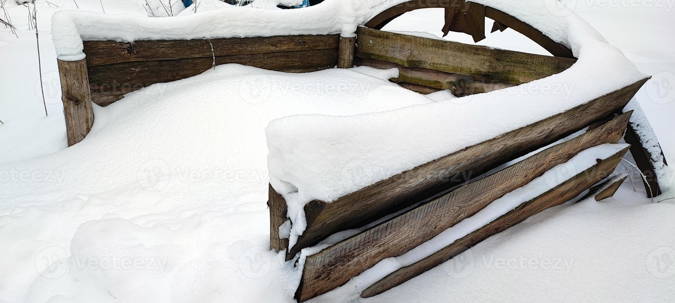 Compost pit in winter. A place for harvesting humus, covered with snow. photo