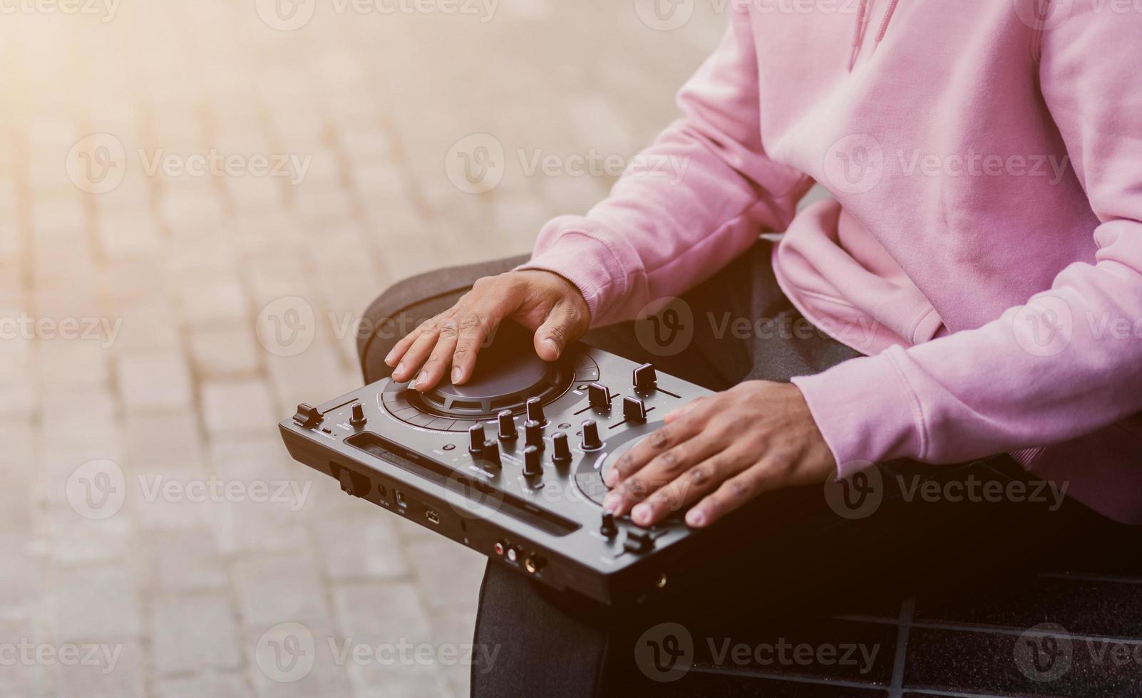 Man dj in hoodie playing music photo