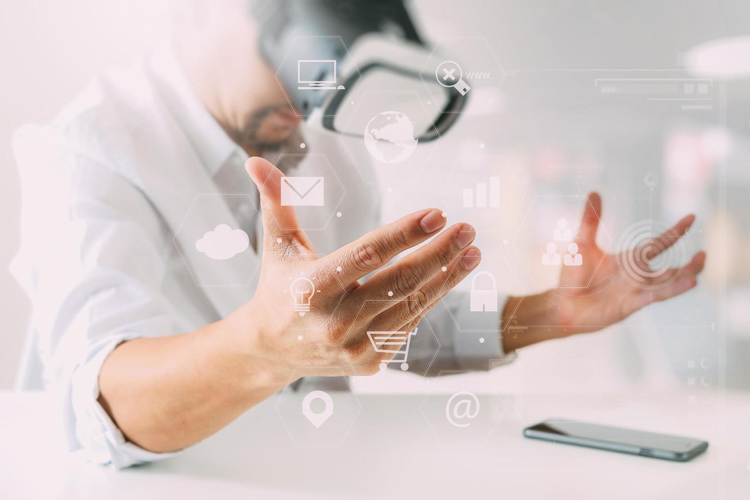 businessman wearing virtual reality goggles in modern office with mobile phone using with VR headset with screen icon diagram photo